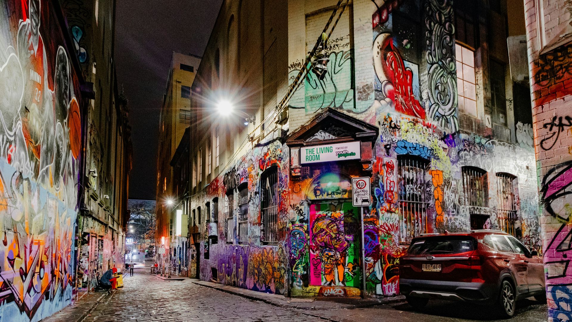 a car parked in front of a building covered in graffiti