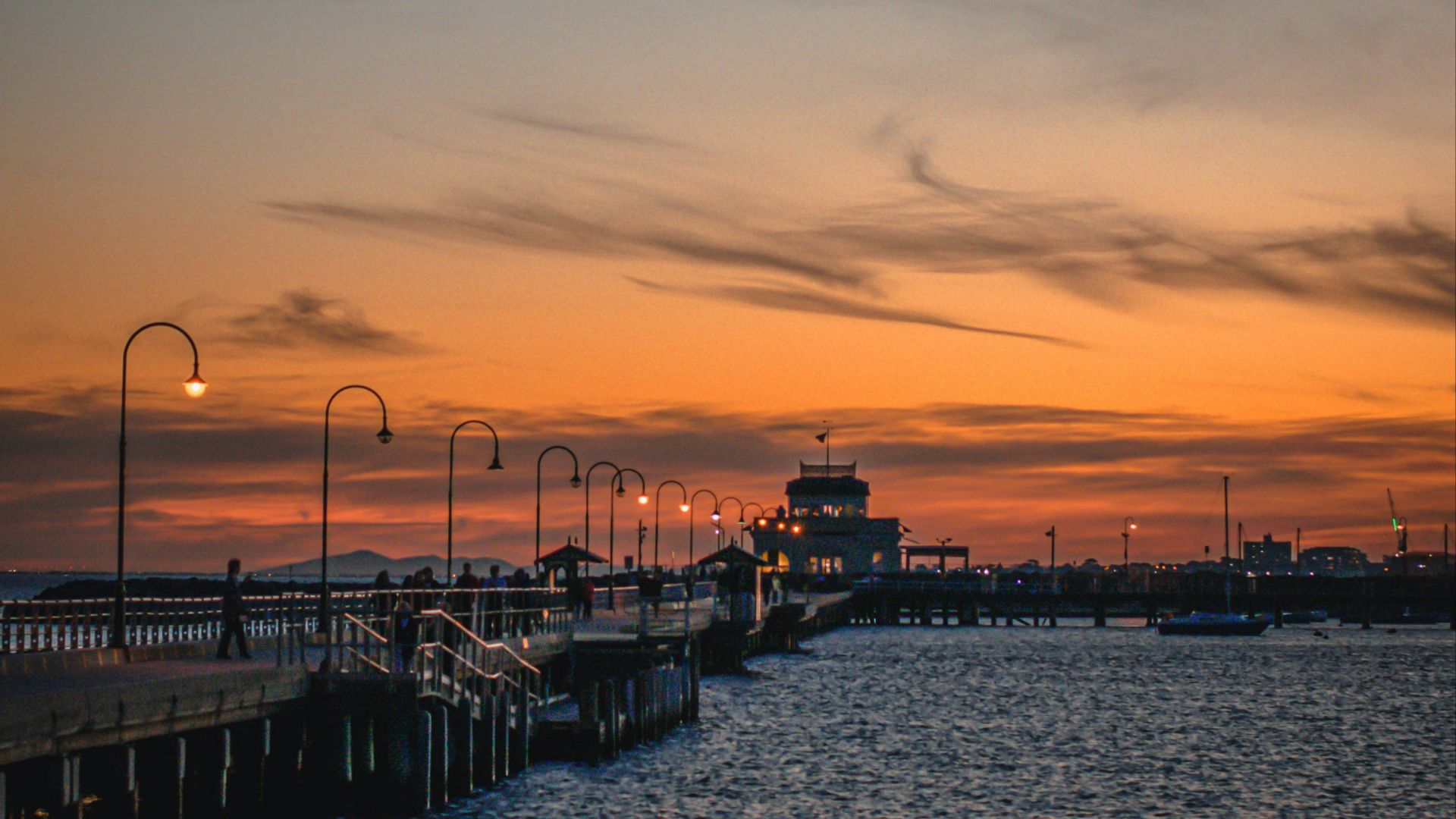 silhouette of people walking on dock during sunset