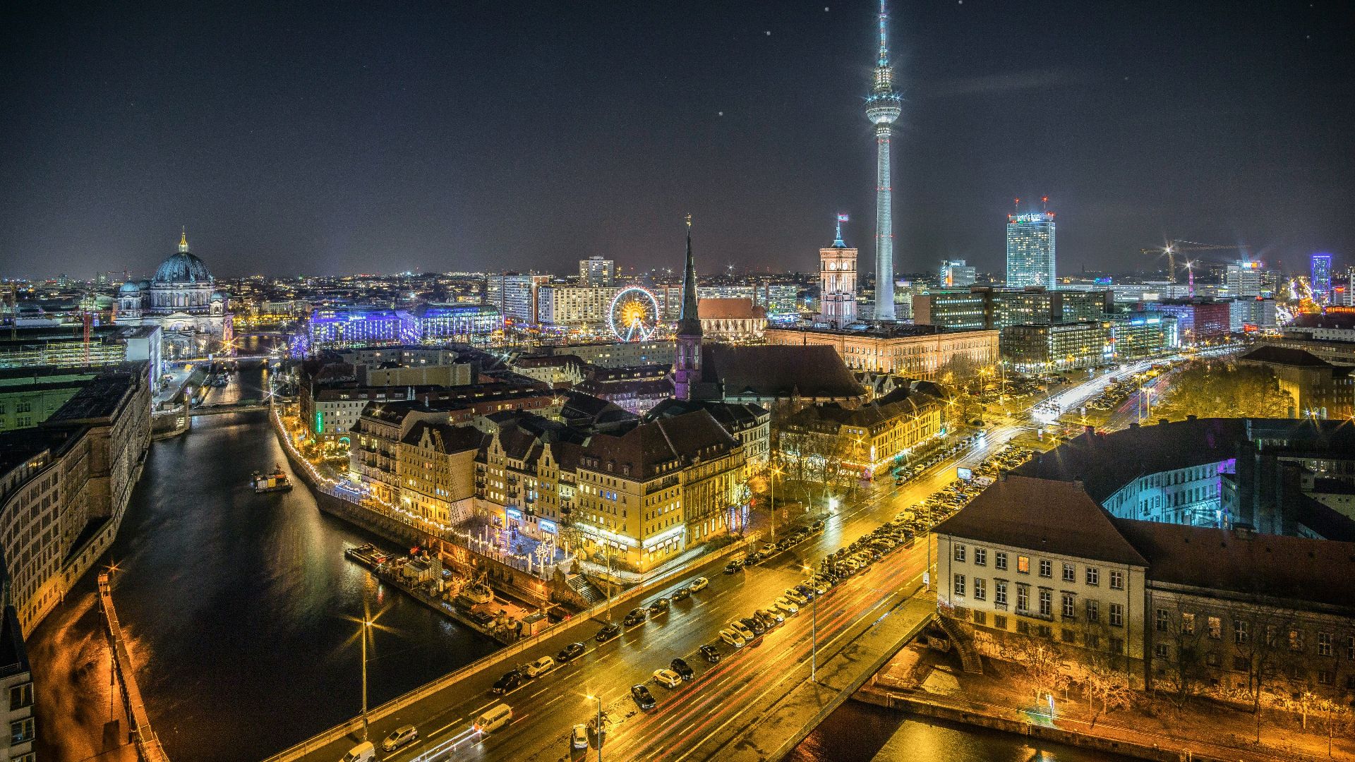 time-lapse photography of vehicle at the road in between the building at nighttime aerial photography