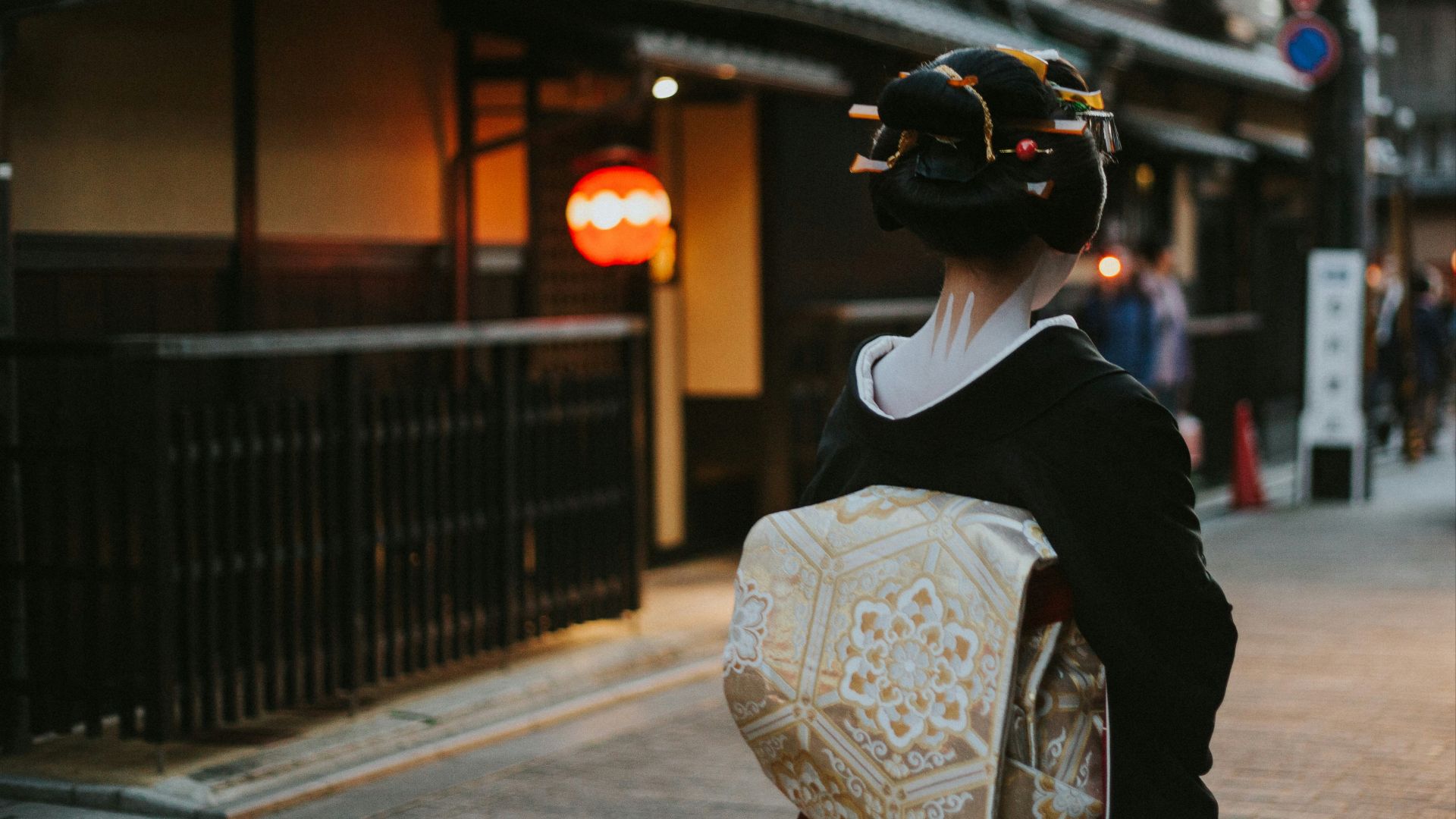 woman in black and white floral kimono walking on sidewalk during daytime