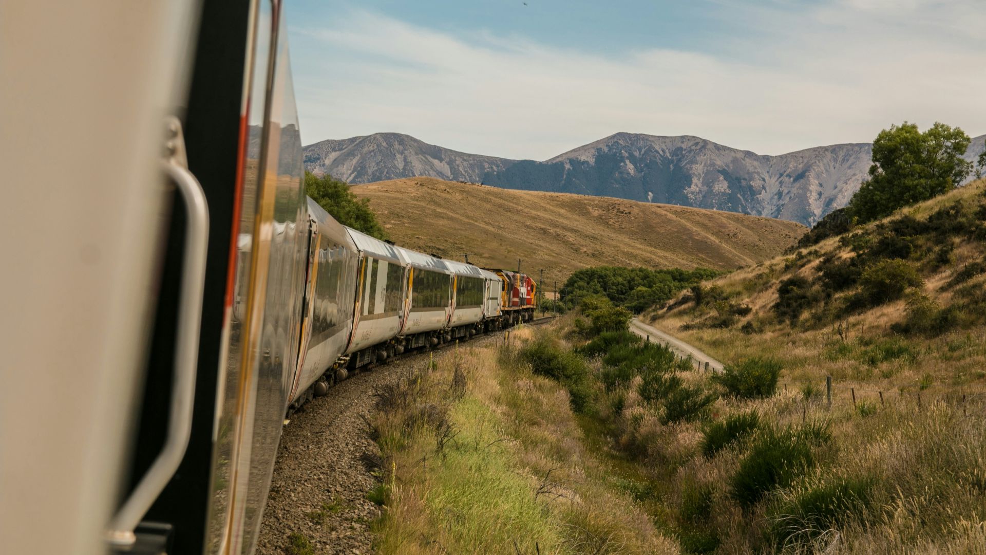 white train with the distance of mountain during daytime