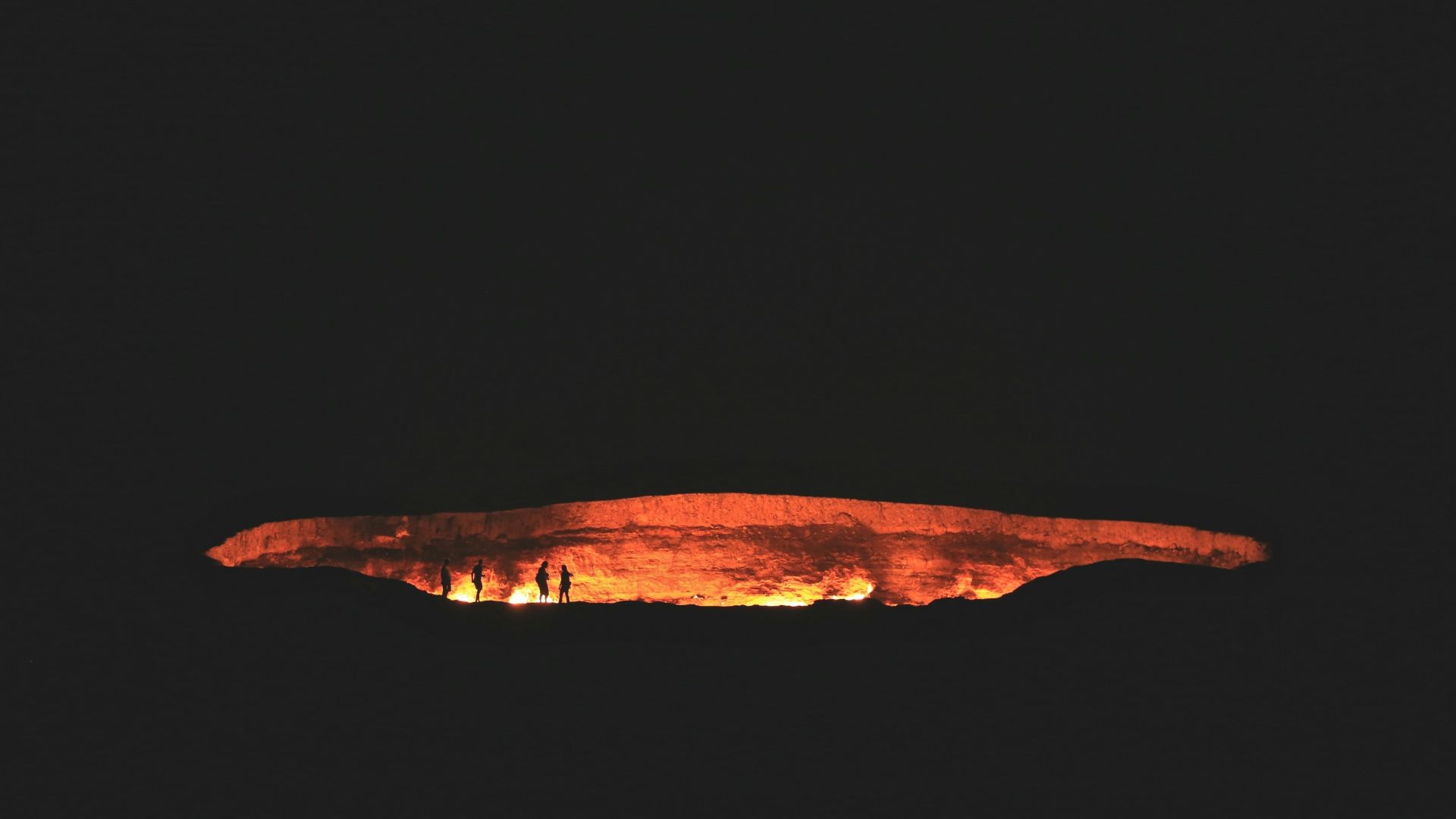 photography of people near cave at night time