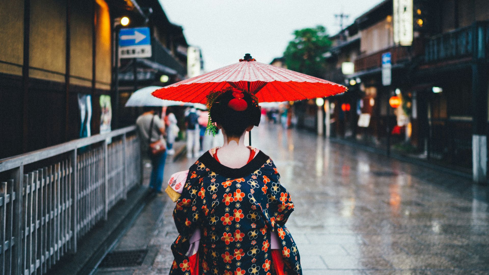 woman holding oil umbrella near on buildings