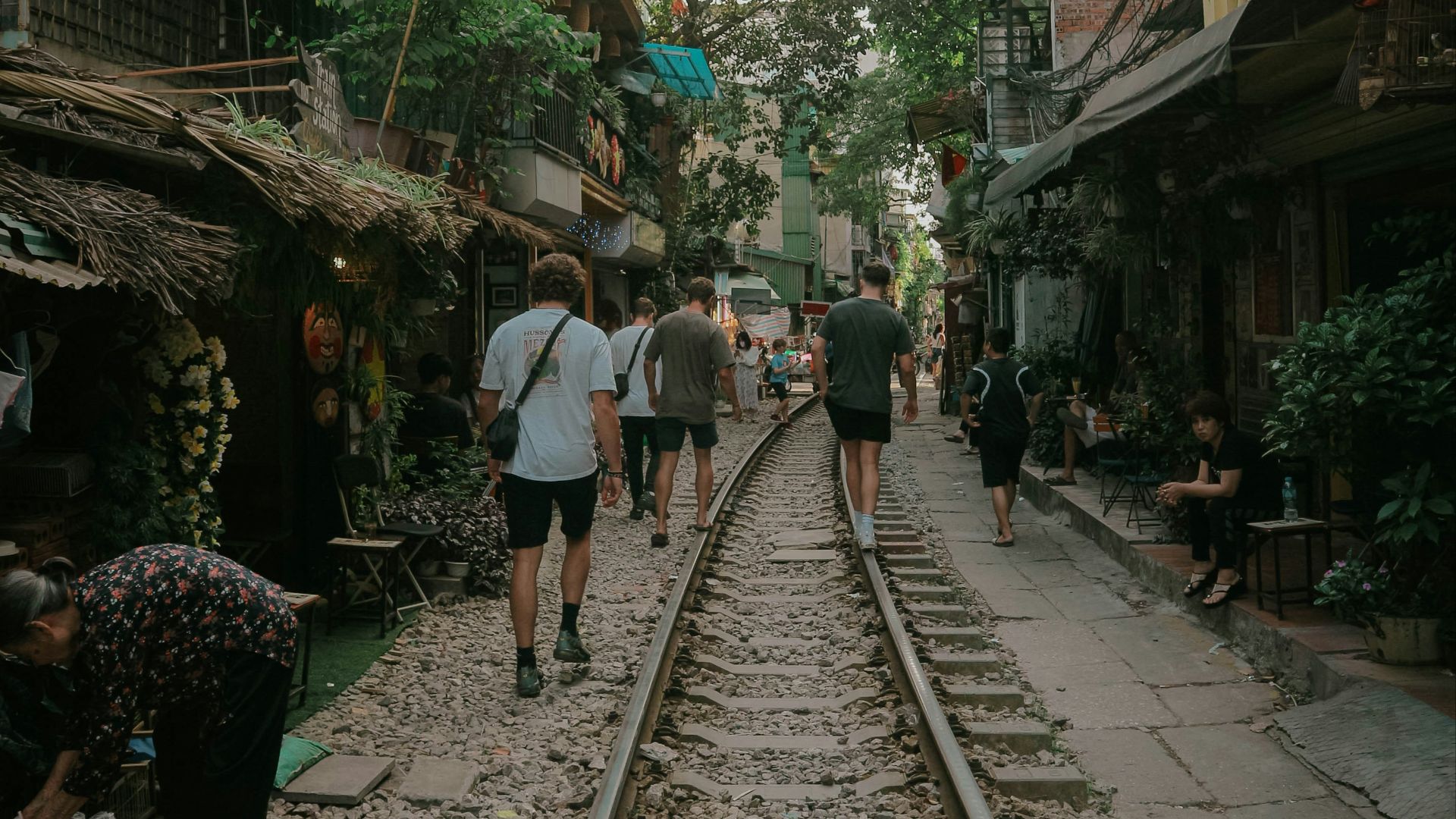 a group of people walking down a train track