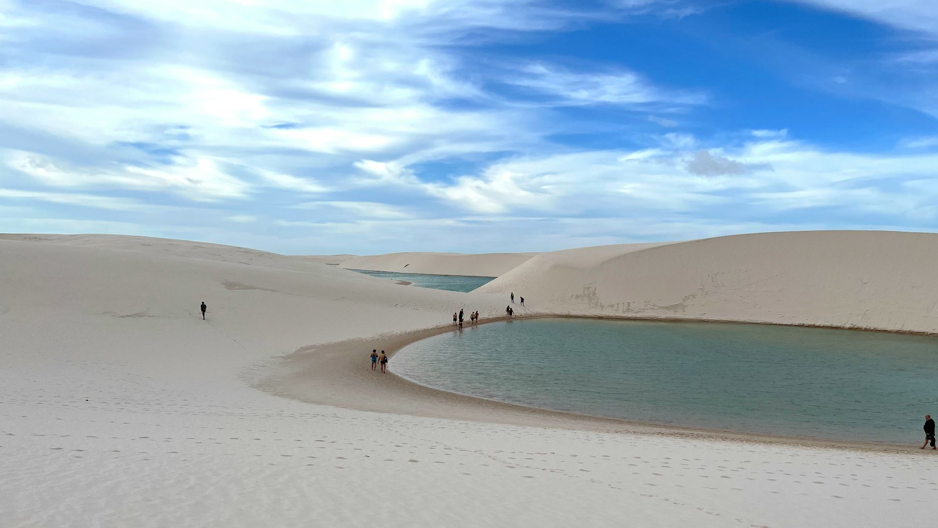 a group of people standing on top of a sandy beach