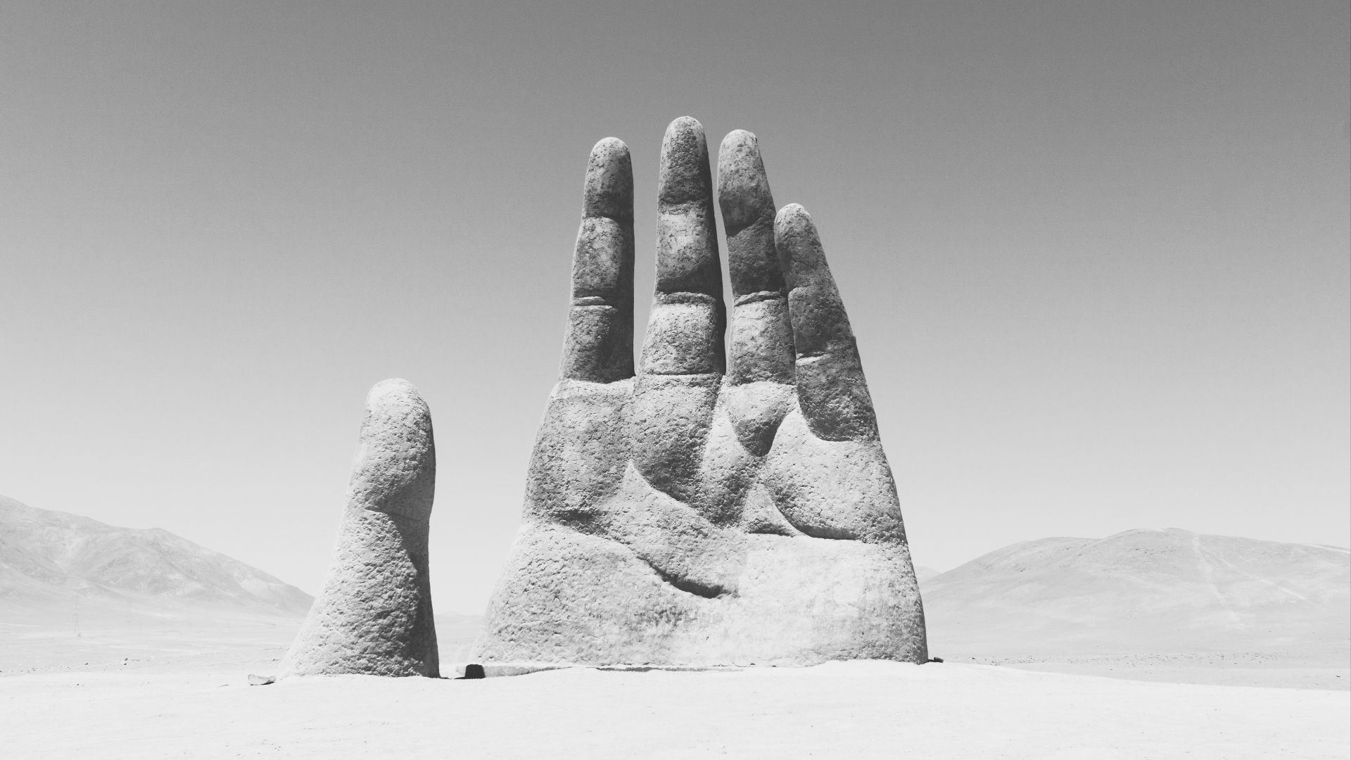 grayscale photography of hand sculpture on sad