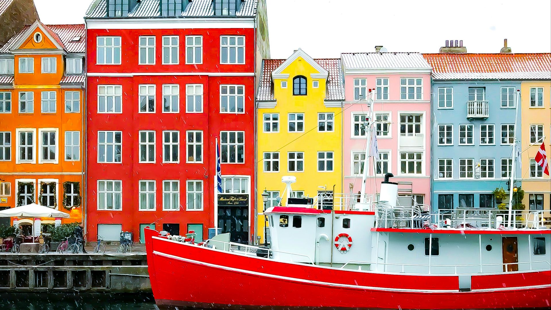 assorted-color buildings near red boat docked on port during daytime