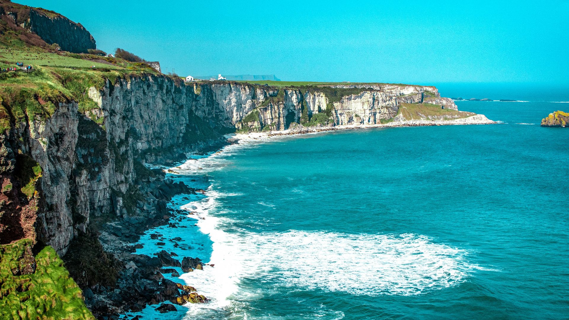white rock cliff beside body of water'