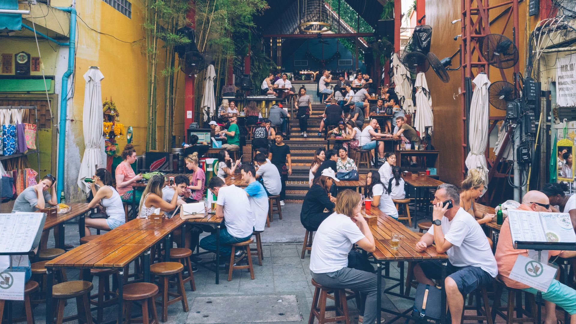 man sitting beside table holding smartphone