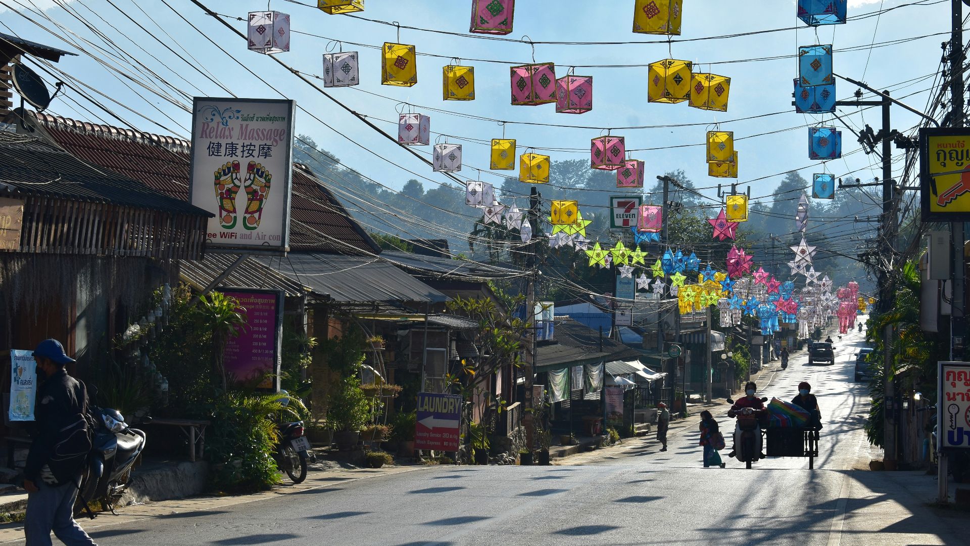 a group of people walking down a street next to buildings