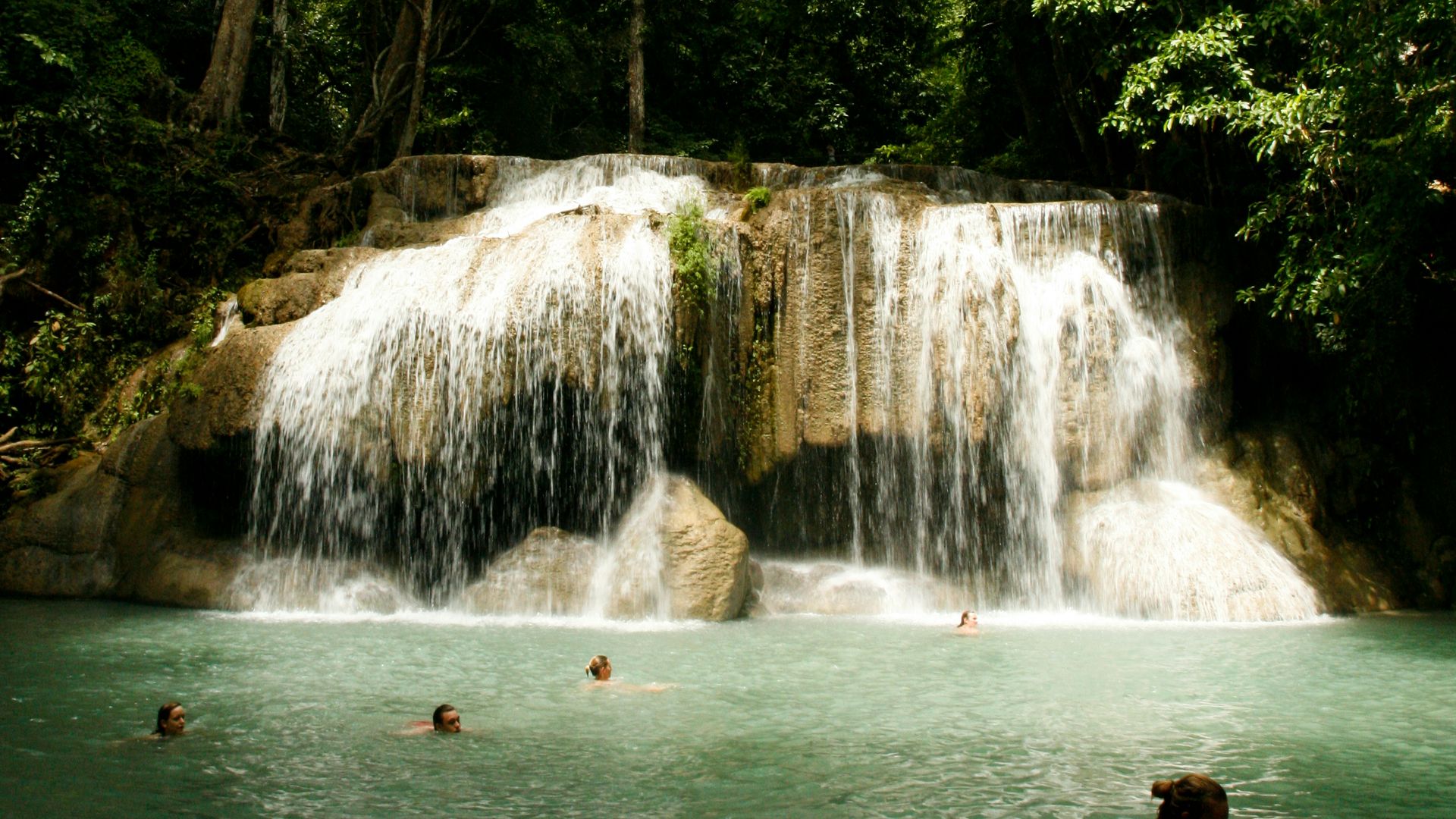 waterfalls in the middle of green trees during daytime