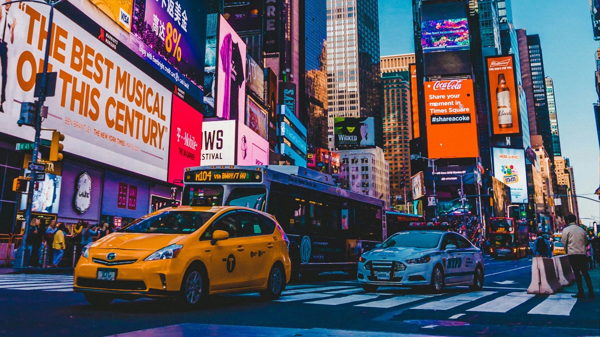 cars parked on street near high rise buildings during night time