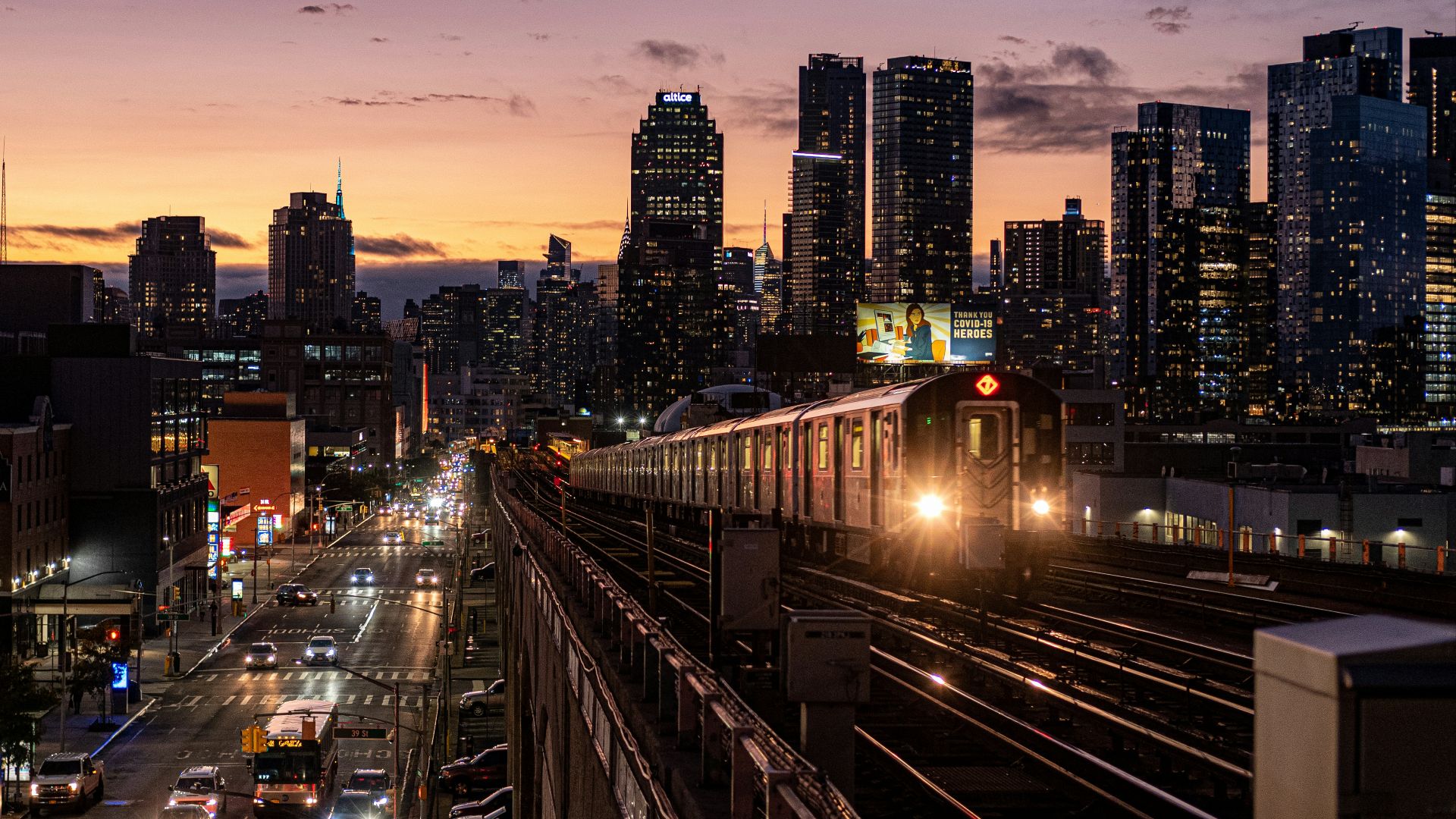 cars on road between high rise buildings during night time