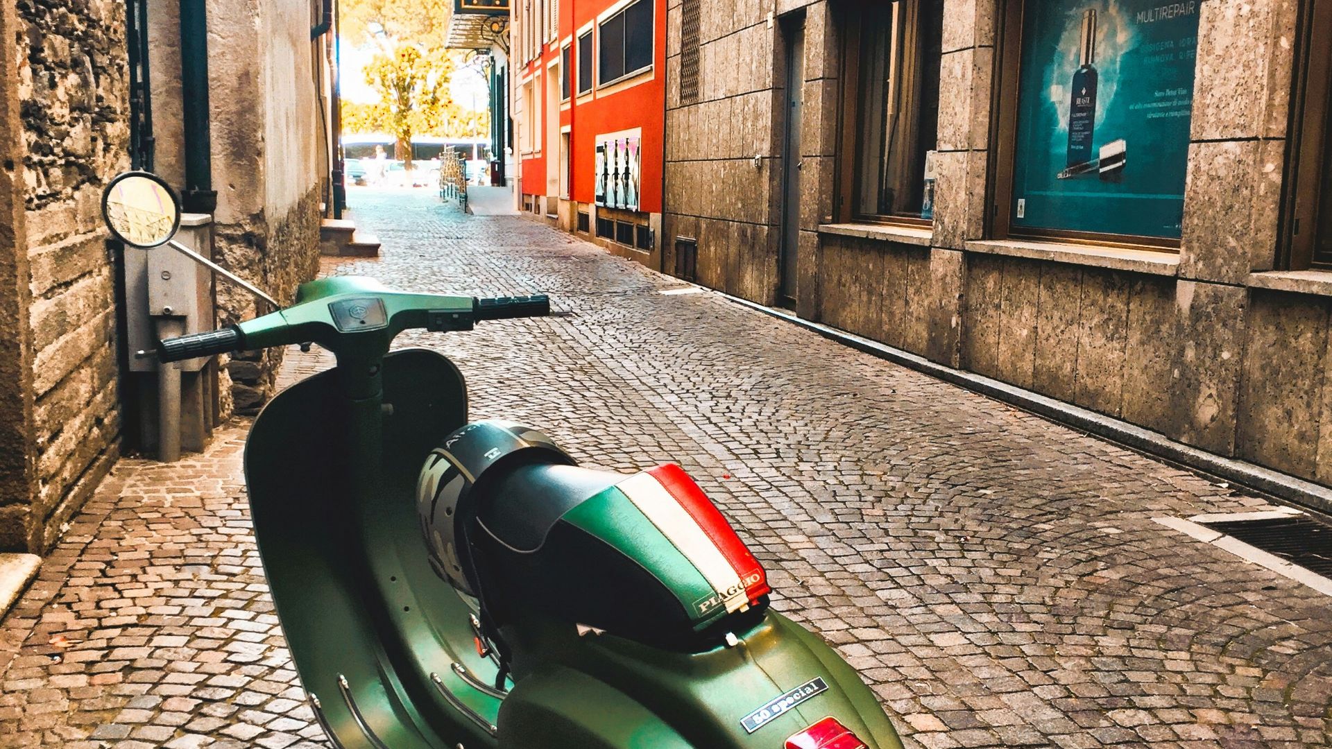 green motor scooter parked beside building