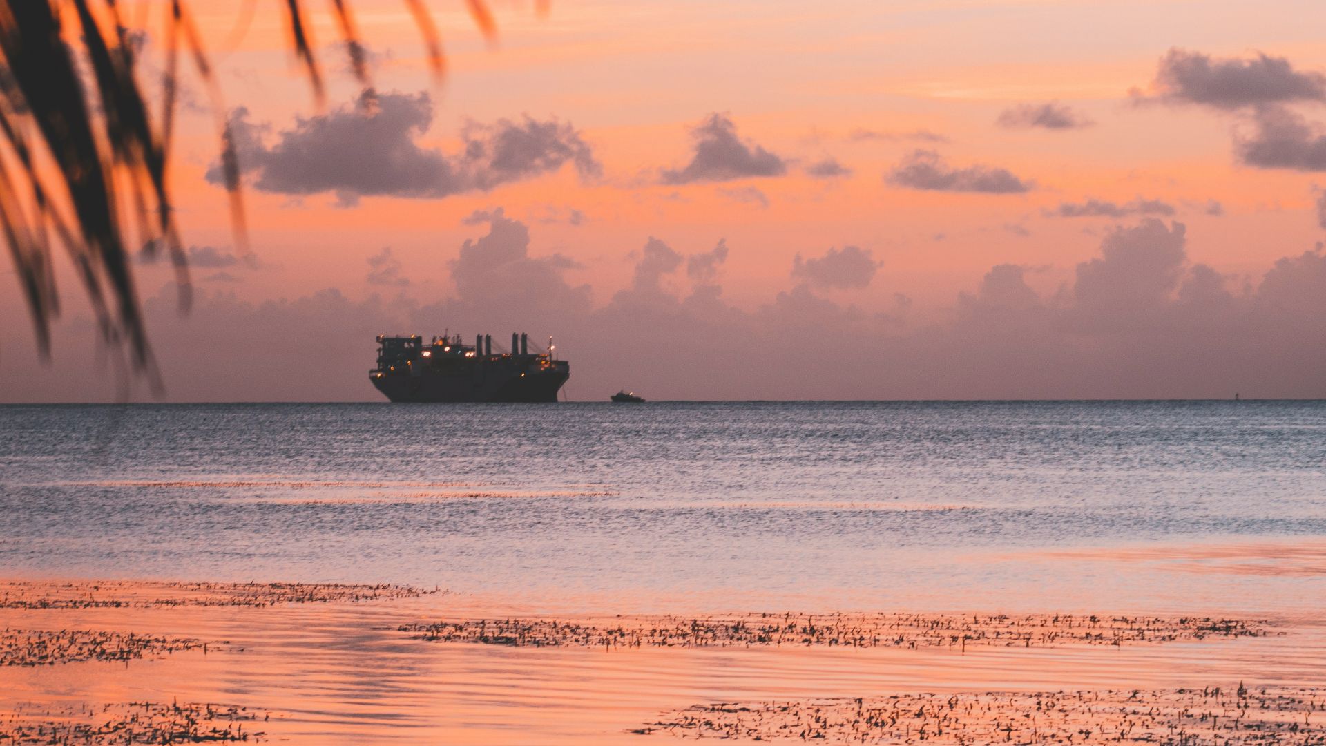 silhouette of ship on body of water during golden hour