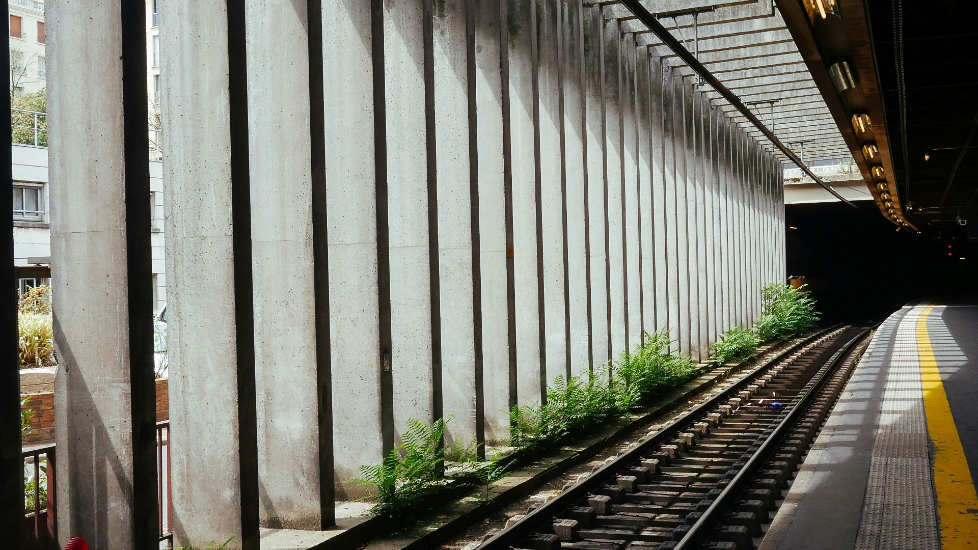 gray concrete road beside train rail