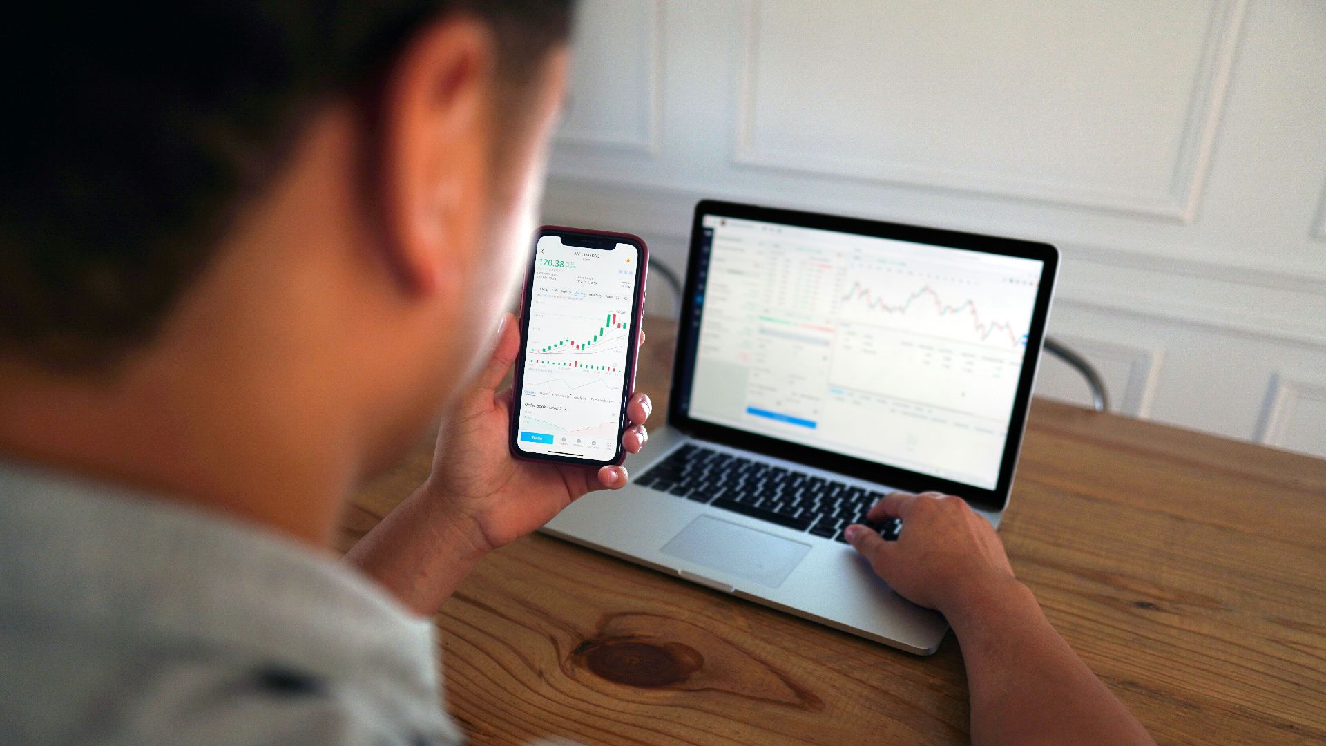 man in gray hoodie holding black smartphone