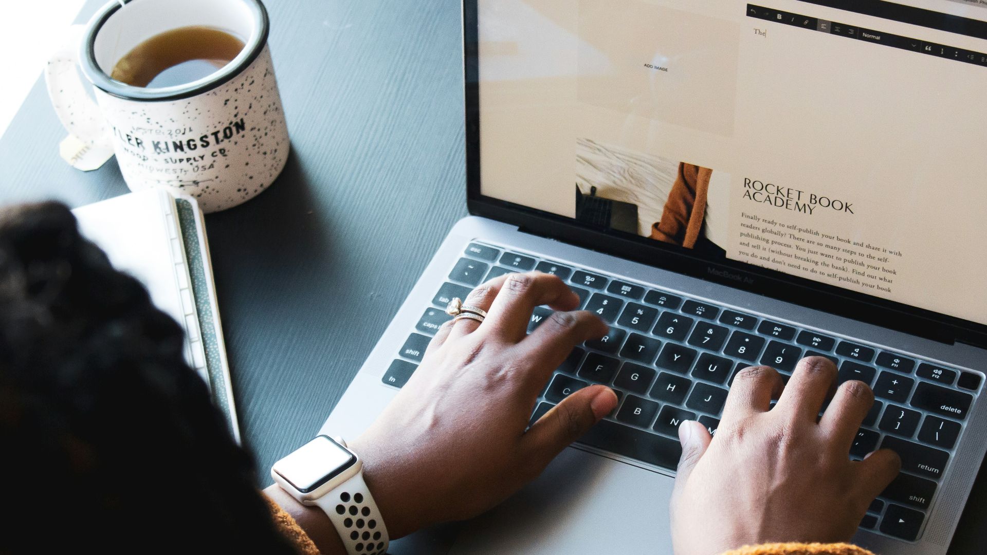 person using macbook pro on black table