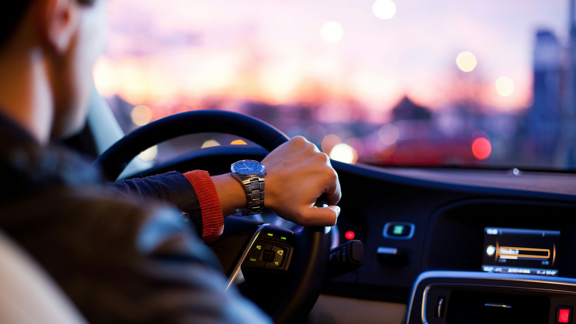 man driving a car wearing wrist watch