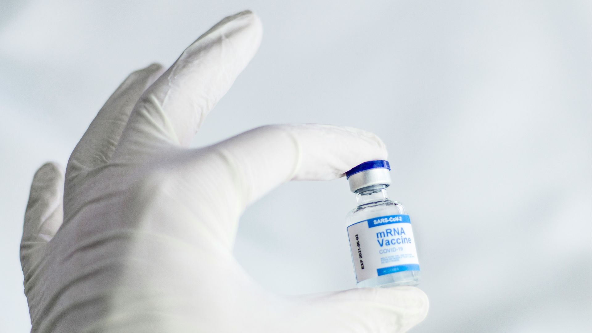 person holding white and orange plastic bottle
