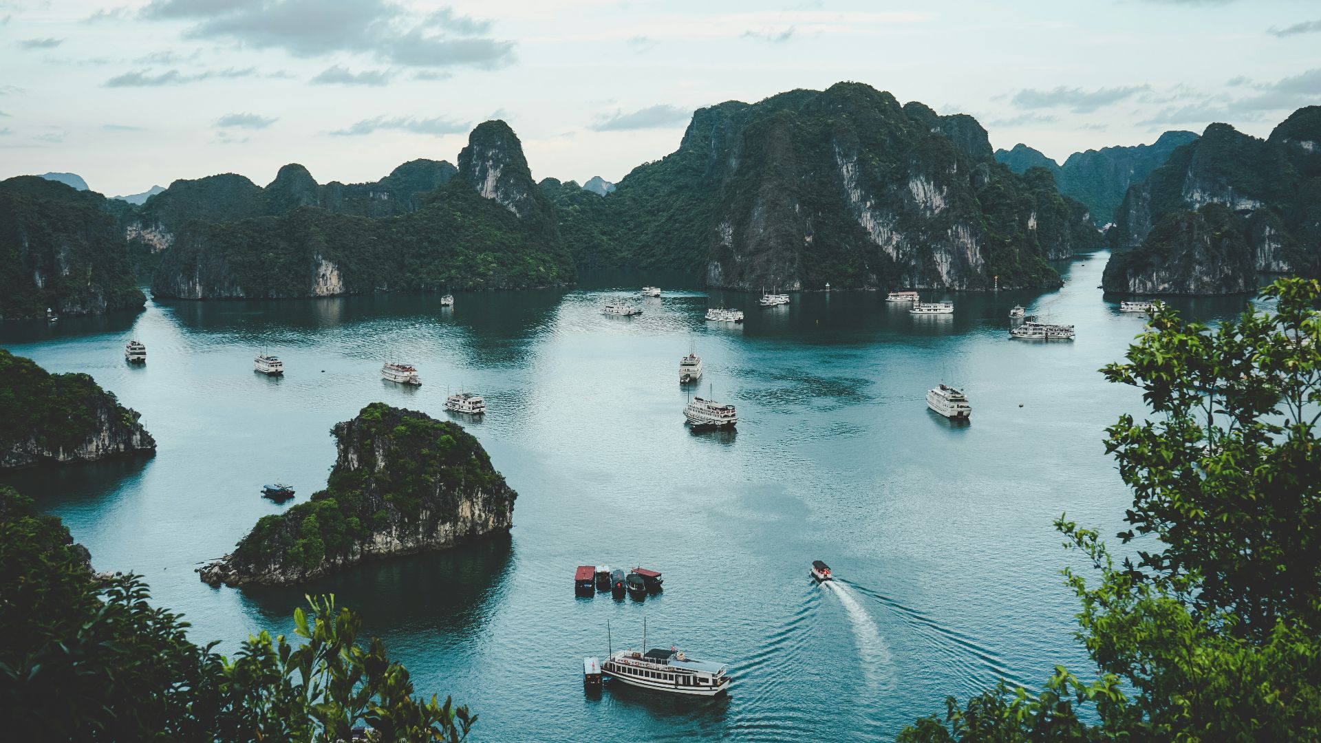 high-angle photography of boats on water near hill during daytime