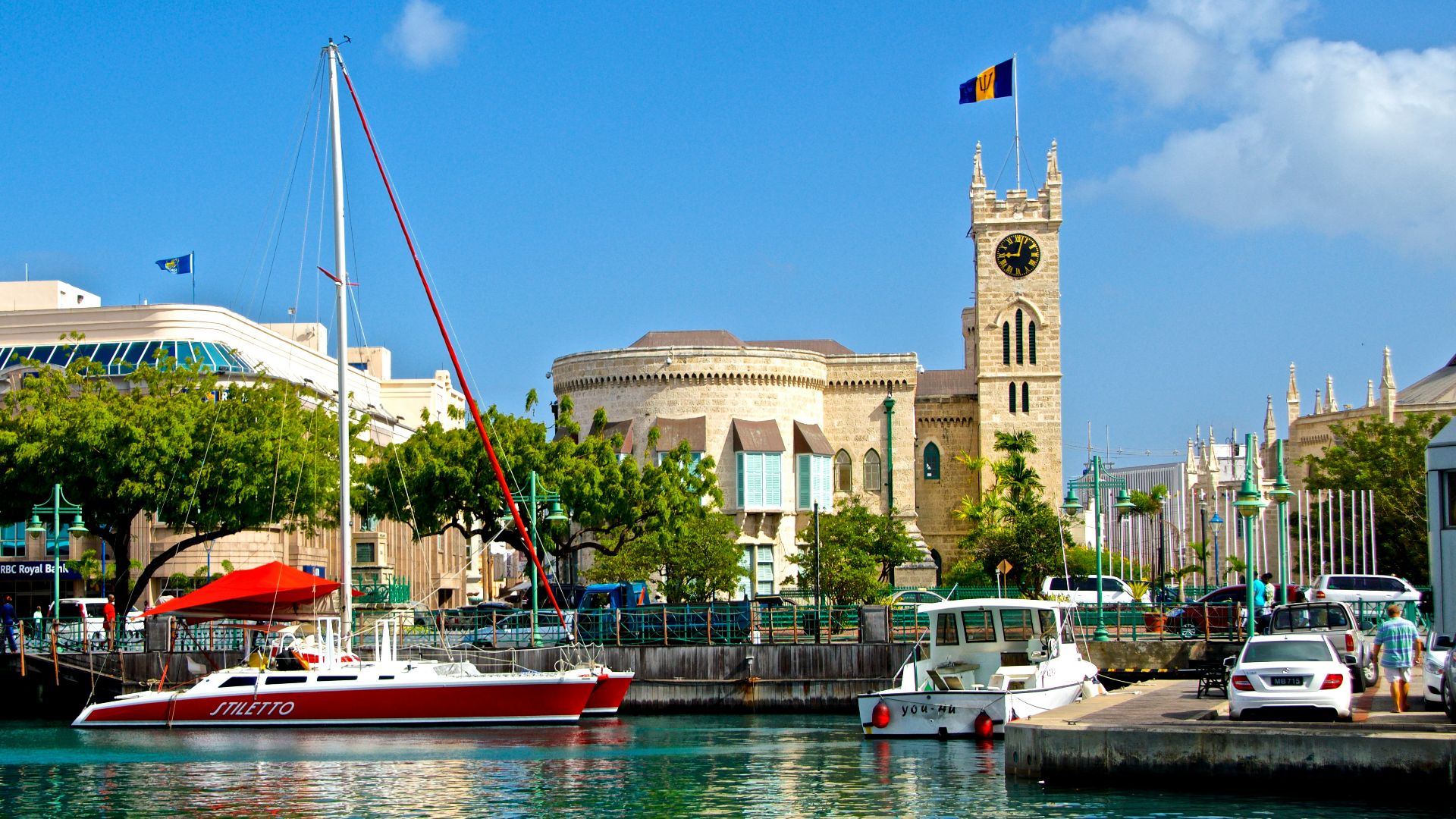 white and red boat on water near brown concrete building during daytime