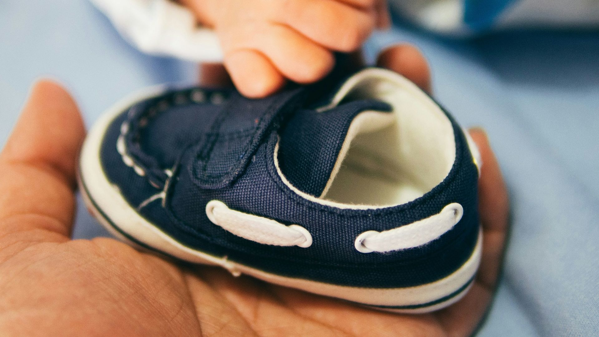 person holding blue boat shoe