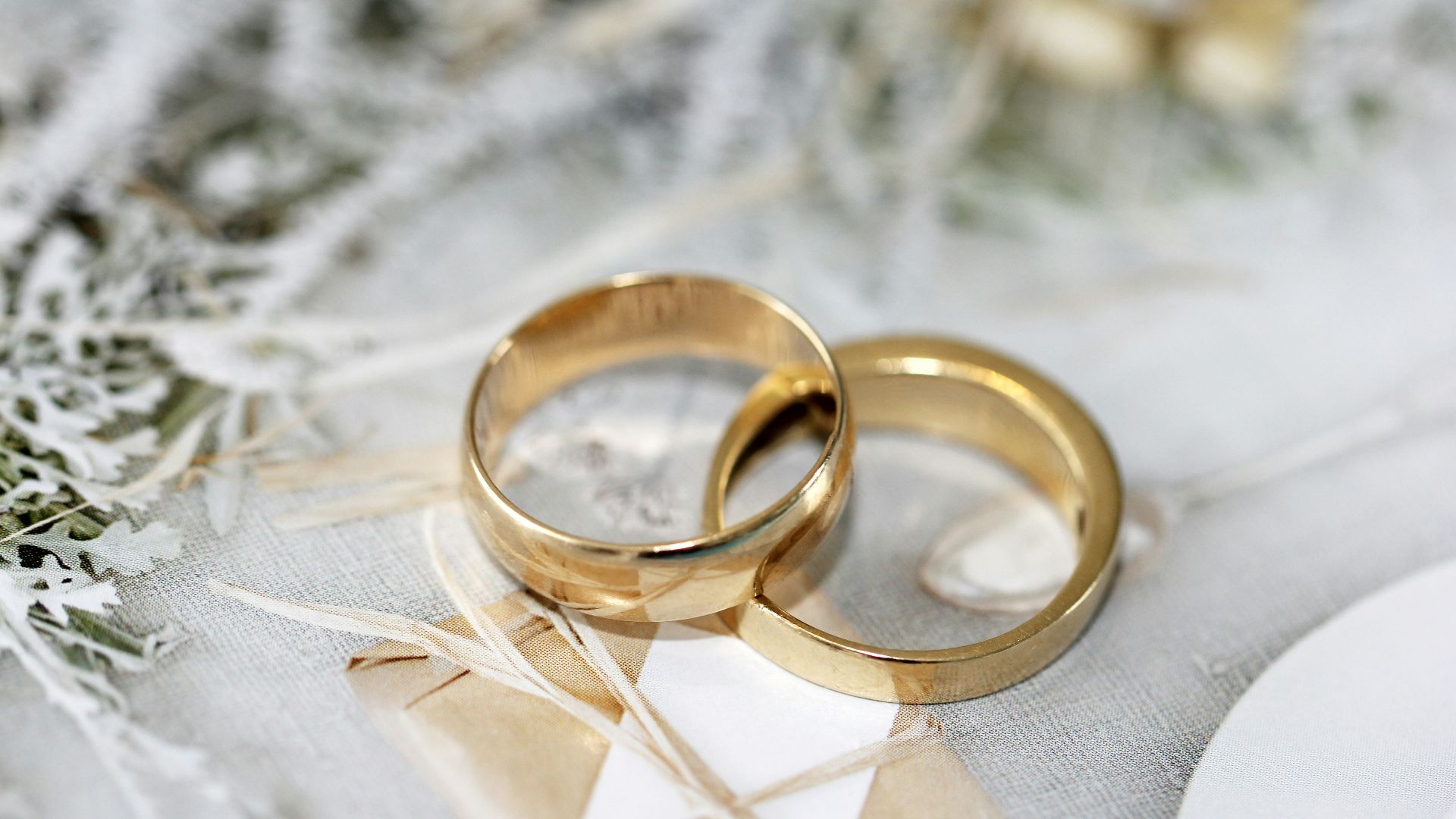 gold wedding band on white textile