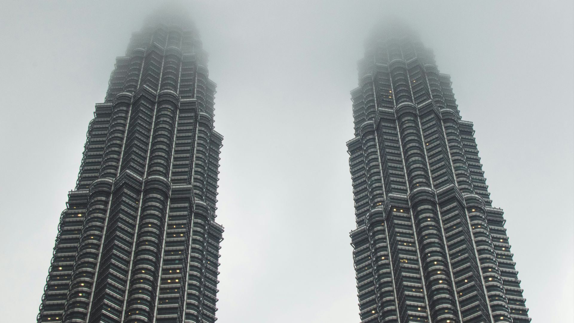 two gray concrete buildings under white sky