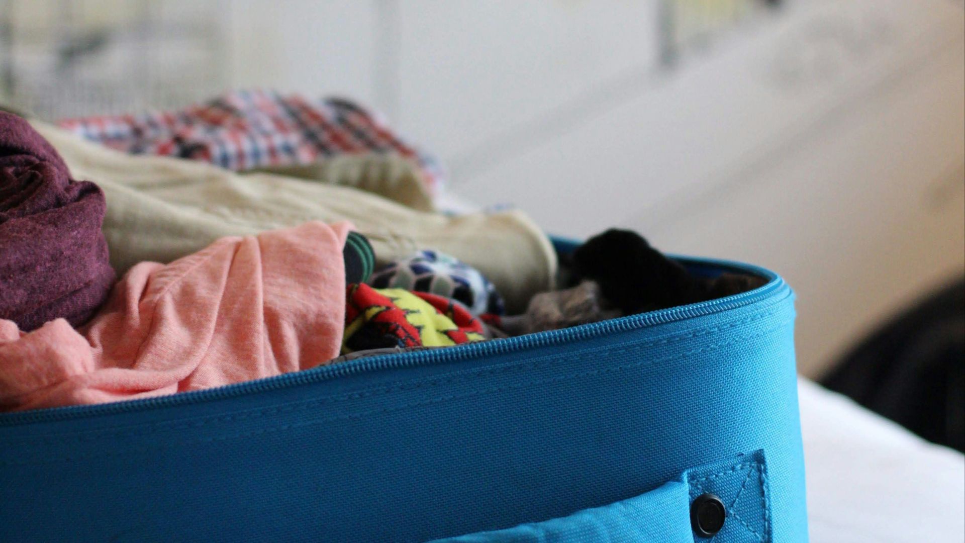 selective focus photo of luggage bag filled with clothes