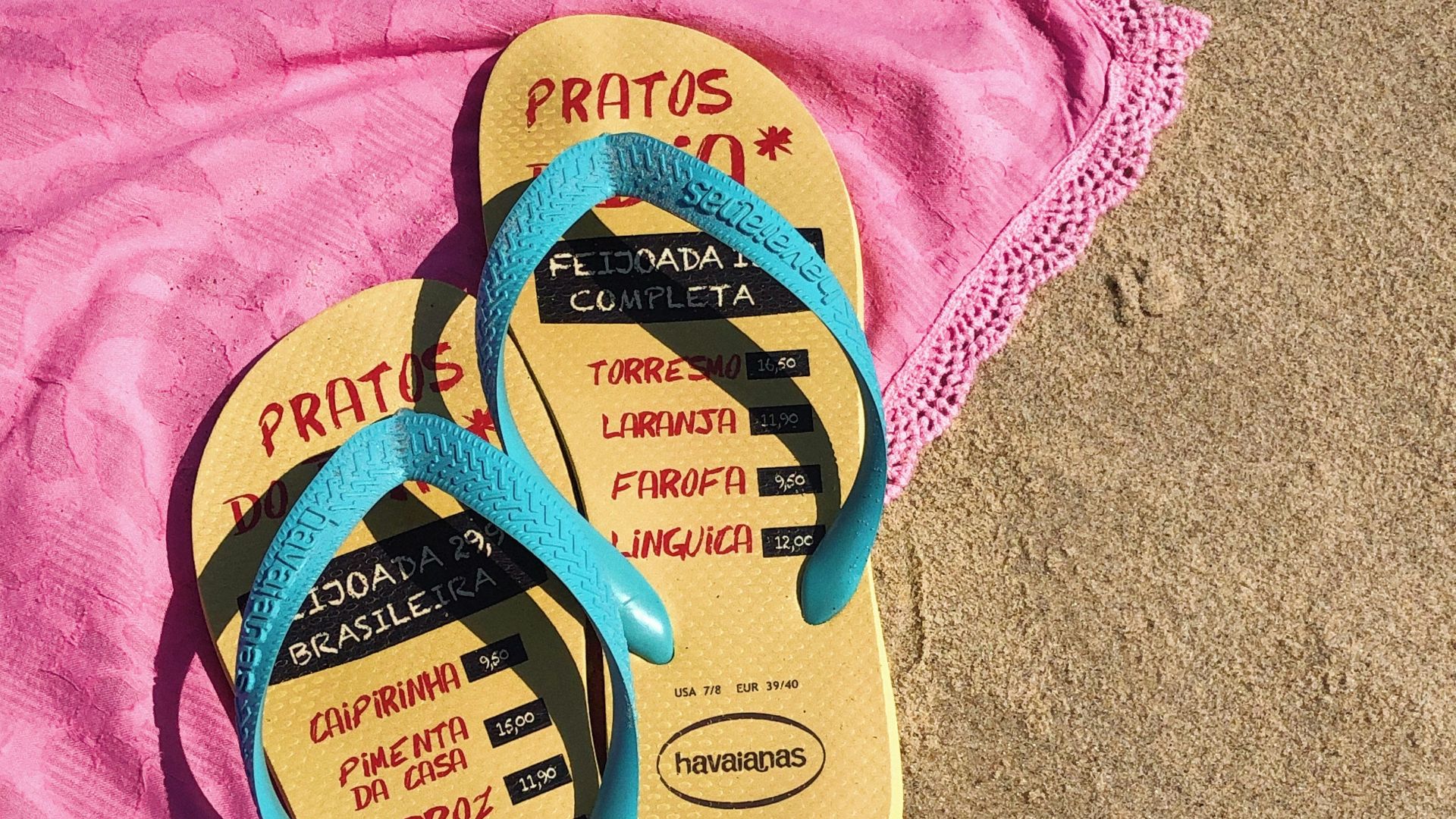 pair of yellow-and-blue havaianas flip-flops on pink textile