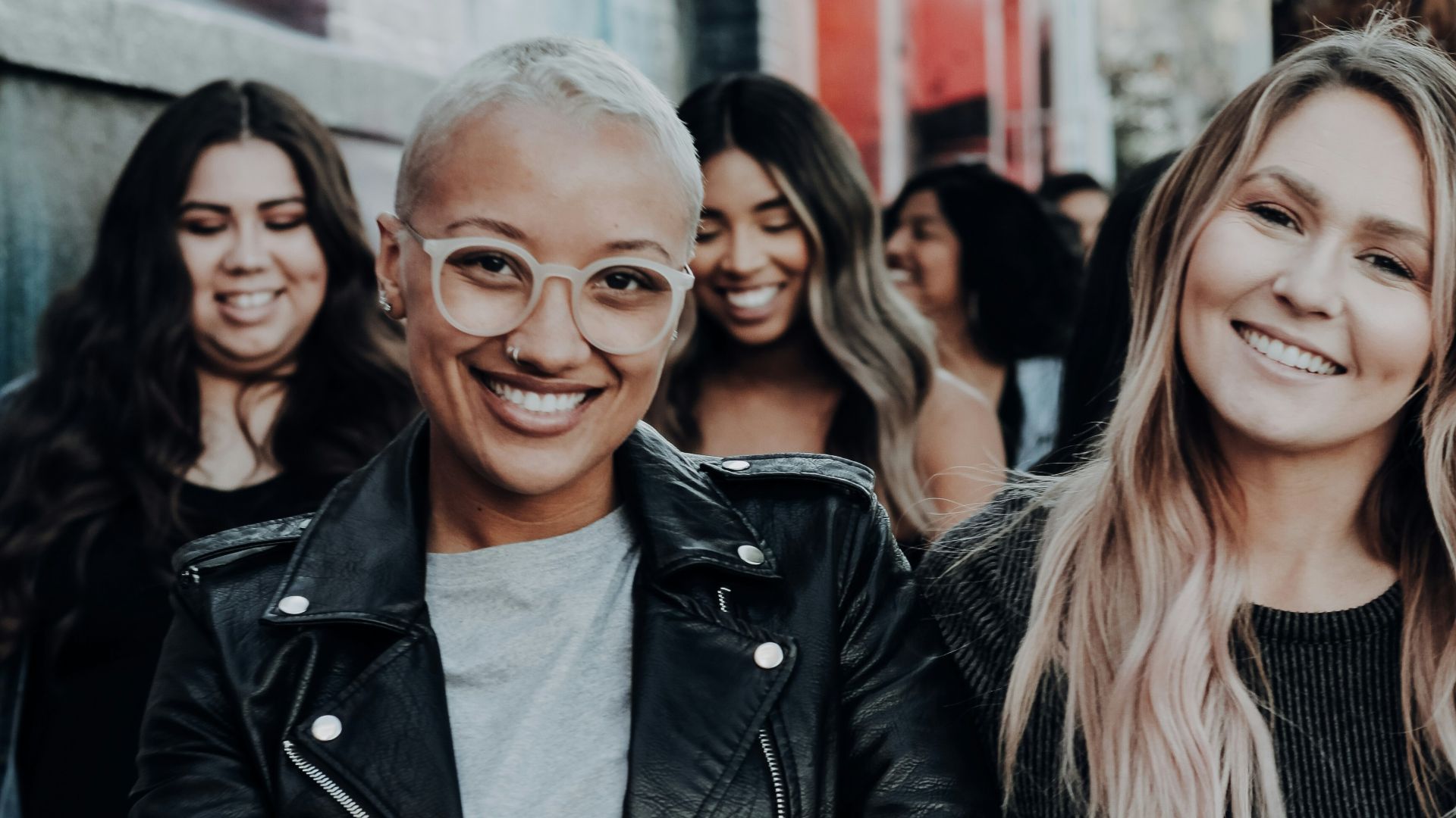 man in black leather jacket beside woman in black and white stripe shirt