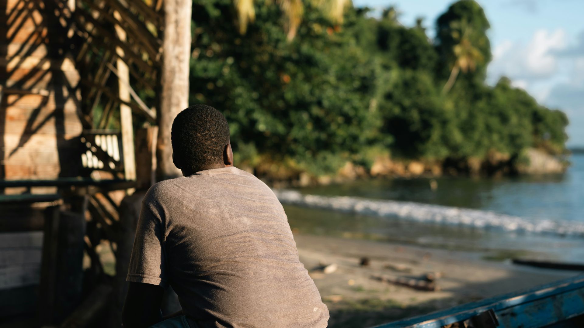 a man sitting on the back of a blue boat
