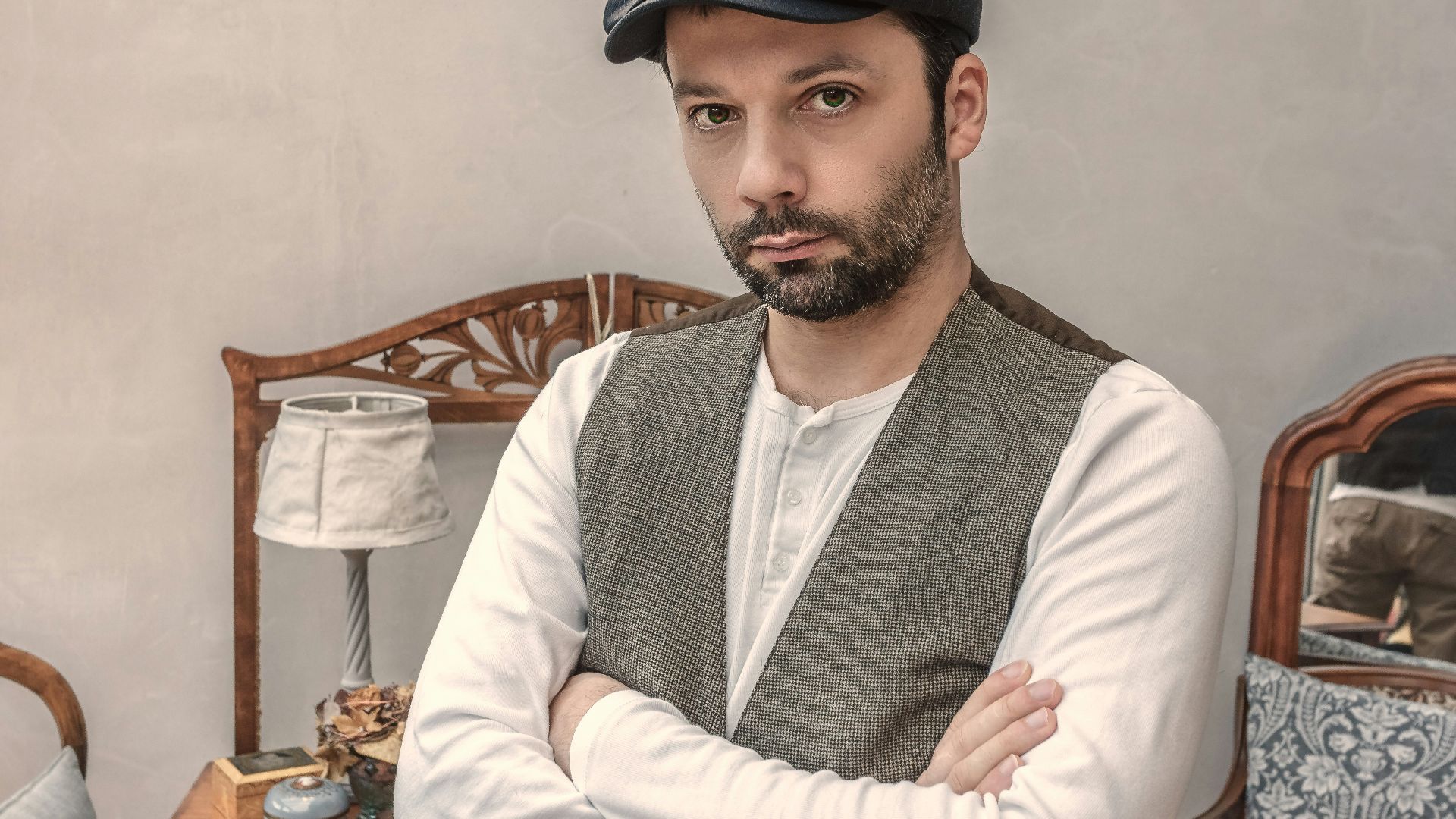 man wearing gray vest near white table lamp