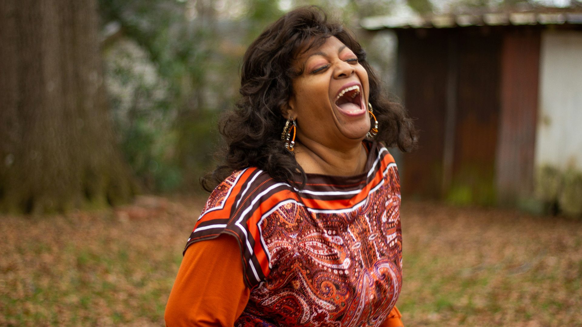 woman in orange and black dress smiling