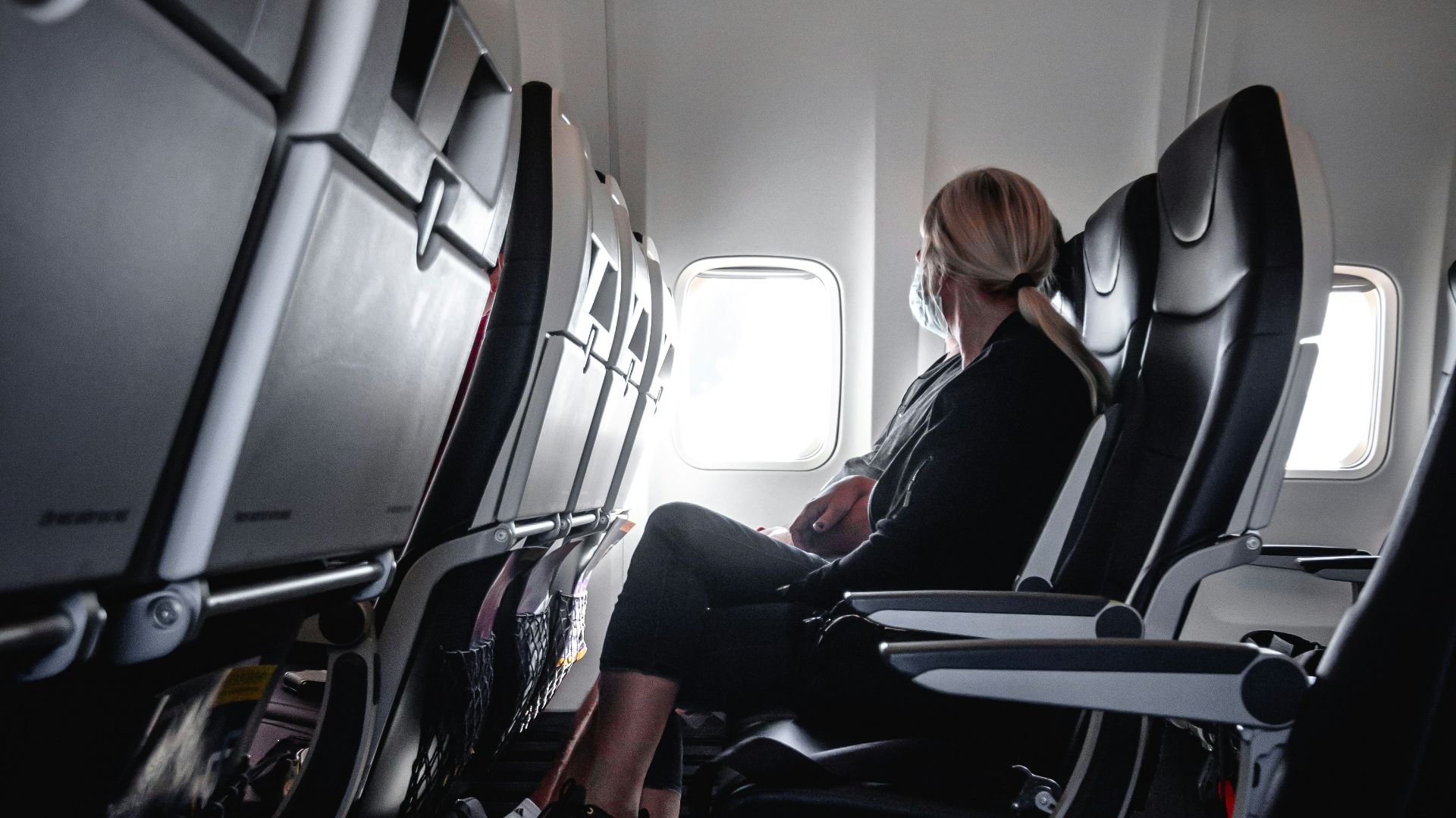 a woman sitting in a seat on an airplane