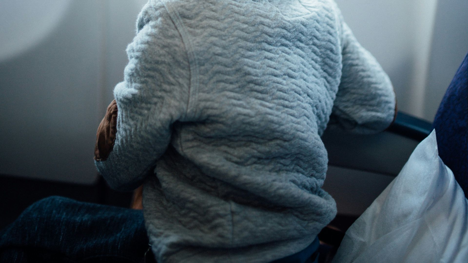 boy sitting on plane seat while viewing window