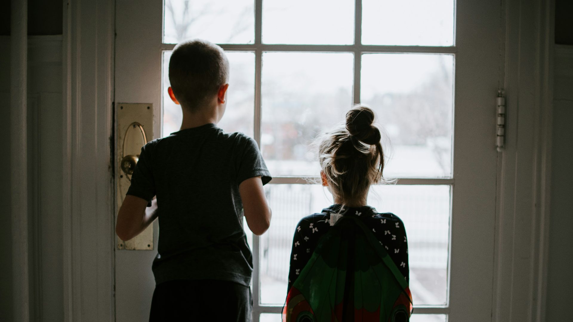 man in black crew neck t-shirt standing beside woman in green and orange dress
