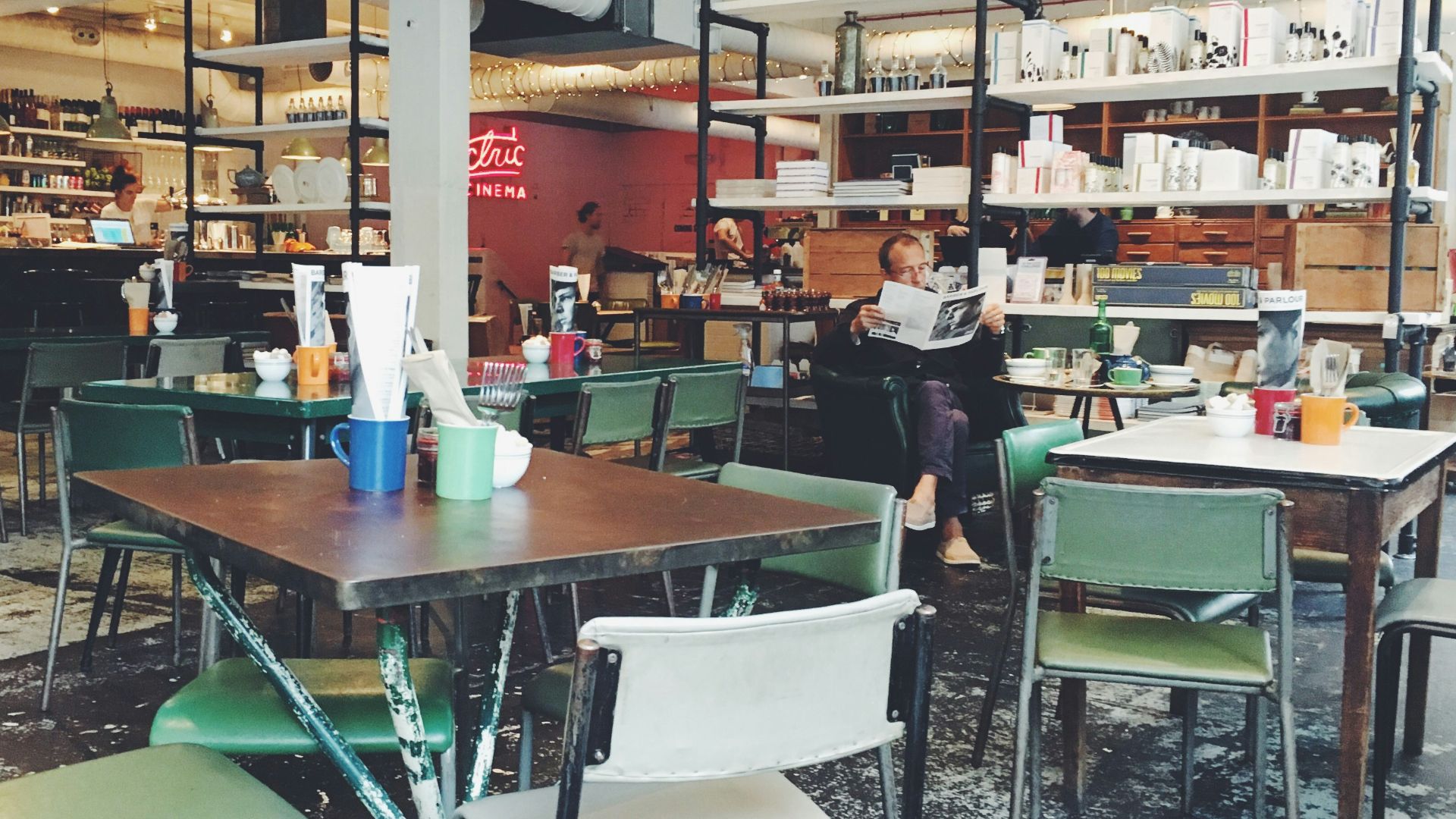 men's sitting green chair reading newspaper