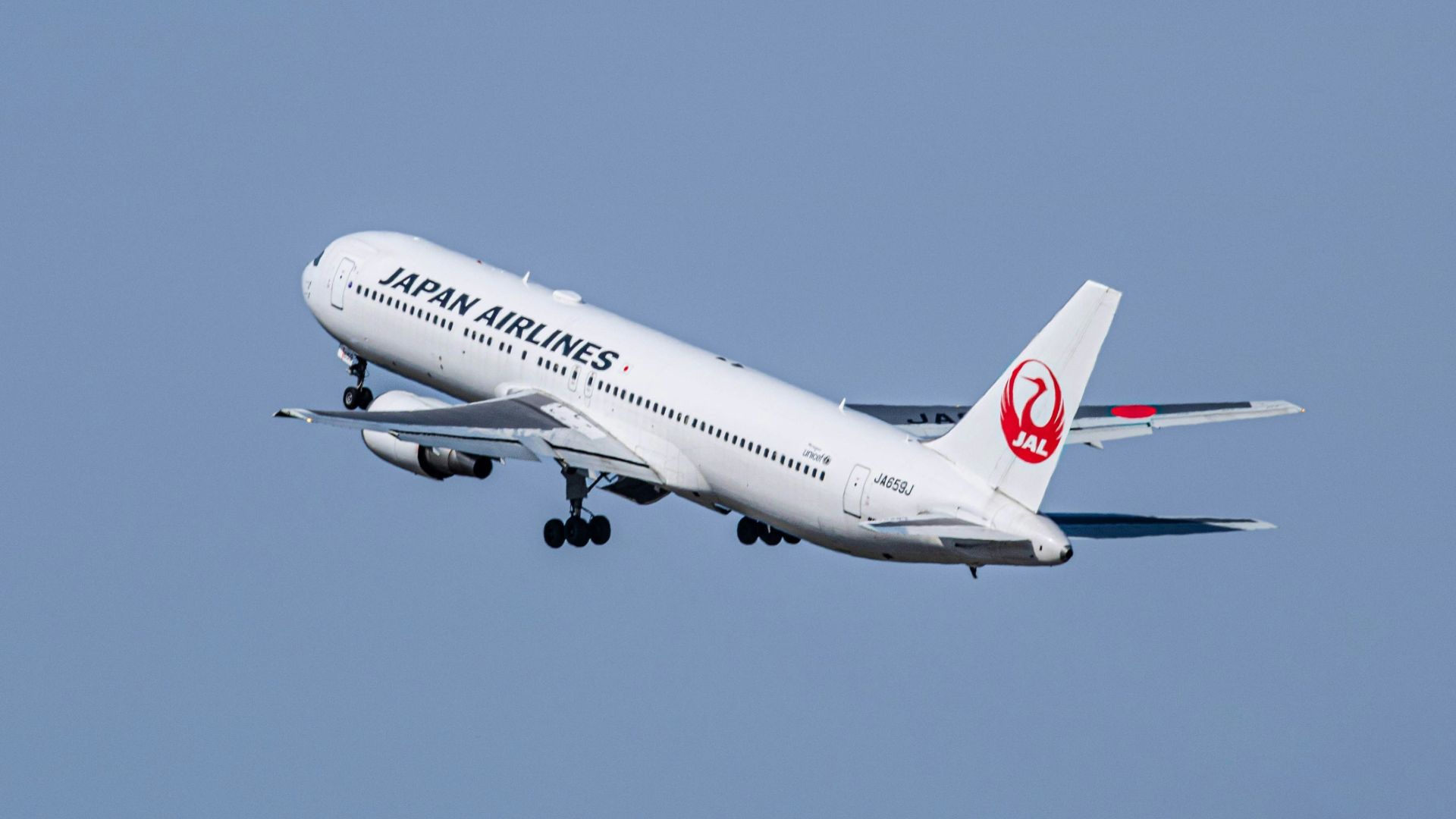 a large jetliner flying through a blue sky