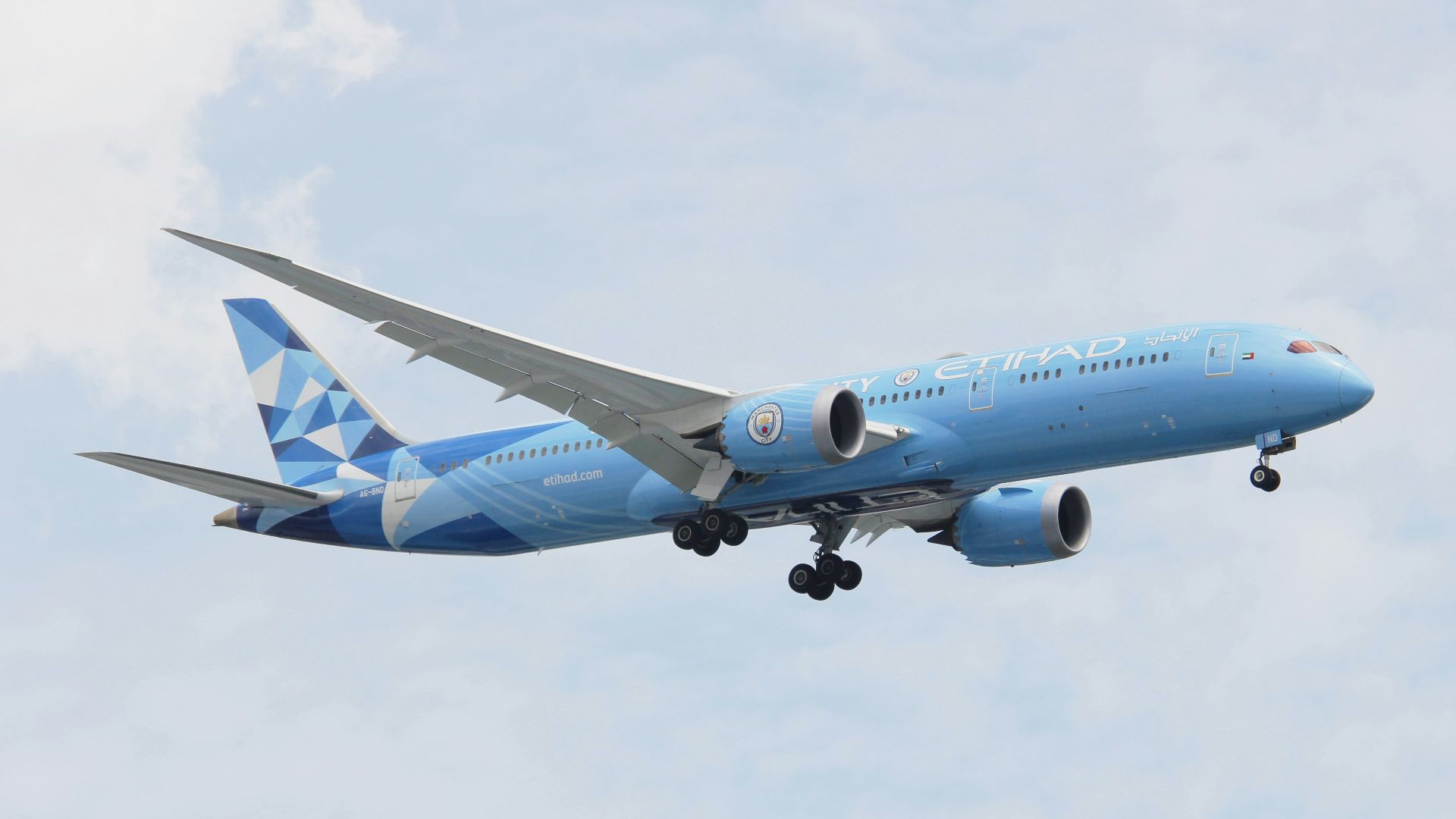 a blue and white airplane flying in the sky
