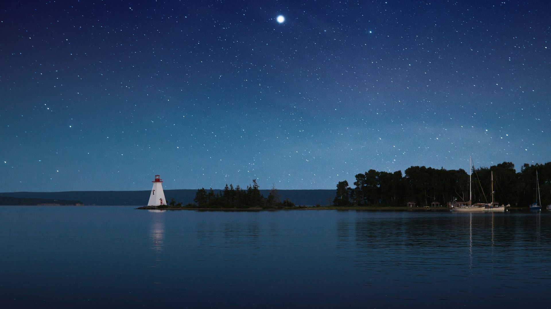 photograph of white lighthouse near calm body of water at night