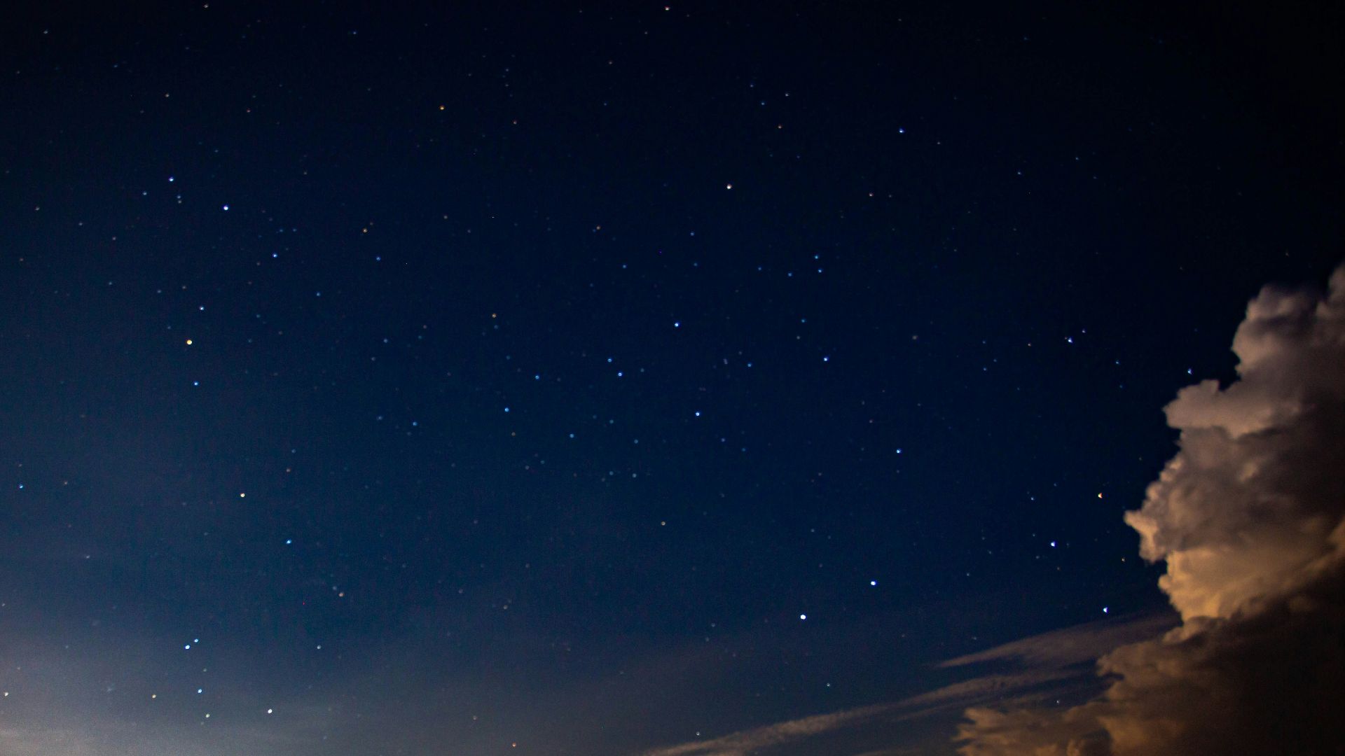 silhouette of person standing on rock under blue sky during night time