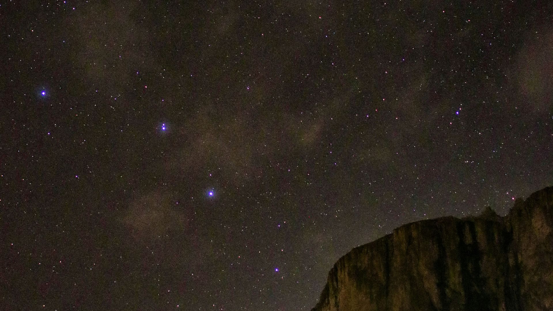 brown rocky mountain under starry night