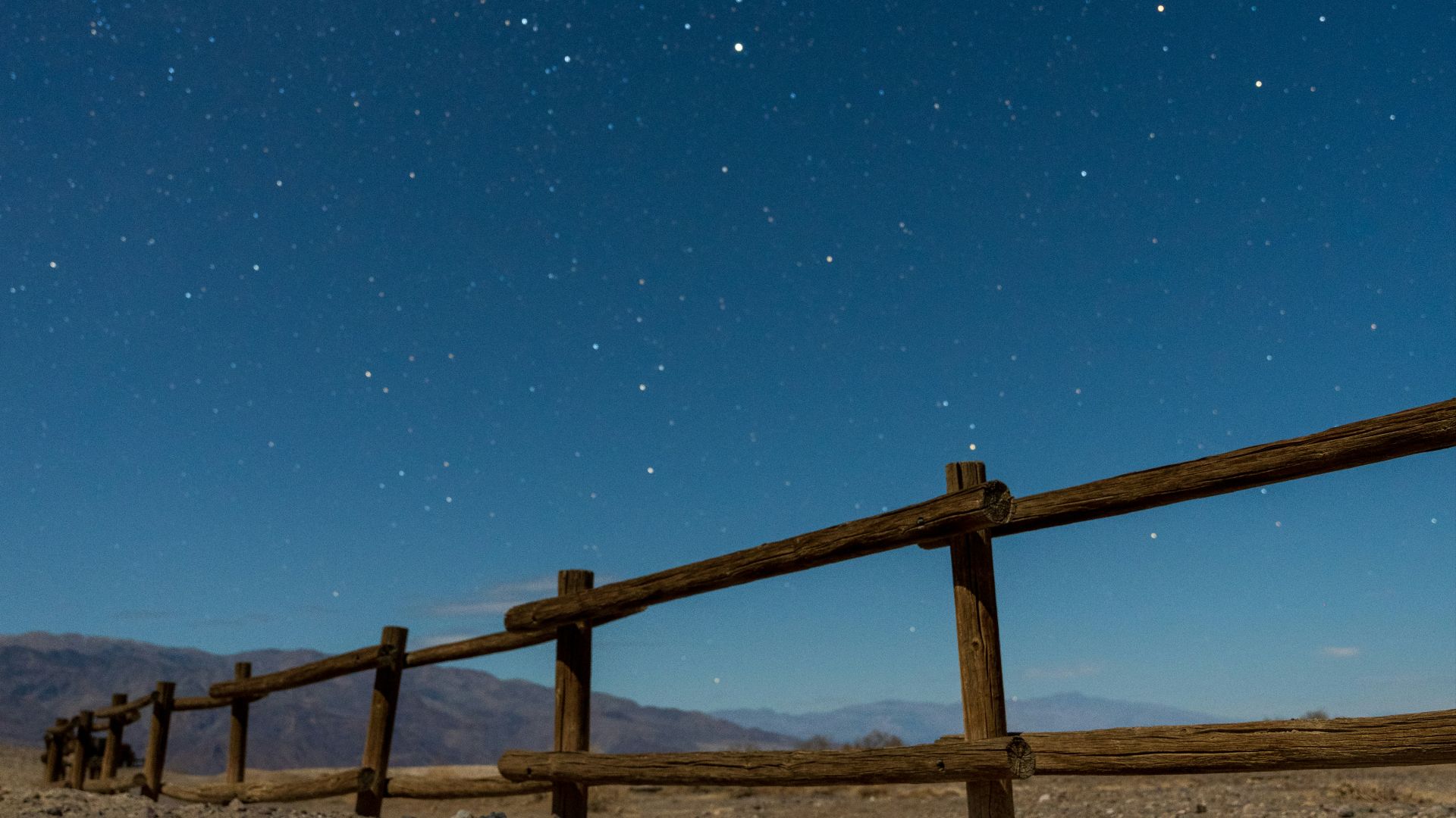 a wooden fence in the middle of a desert