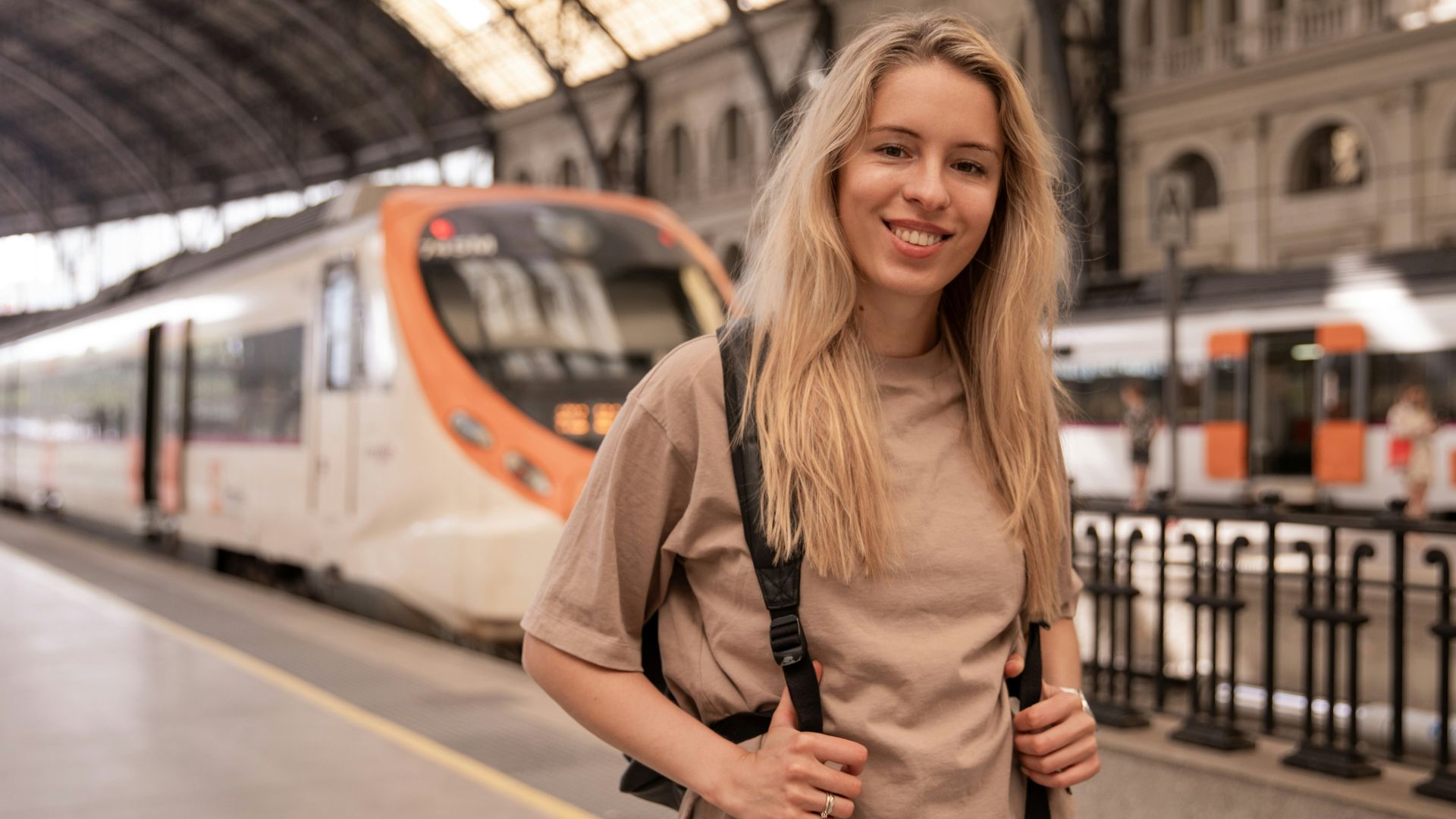 a woman standing in front of a train at a train station