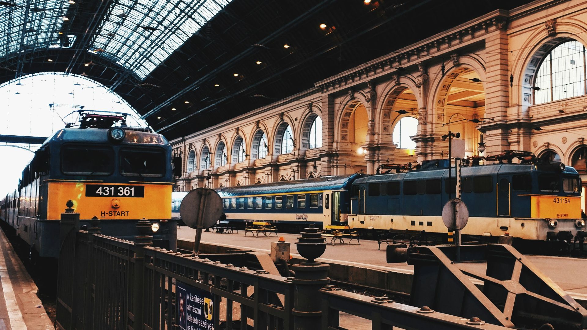 two black-and-yellow trains on train station