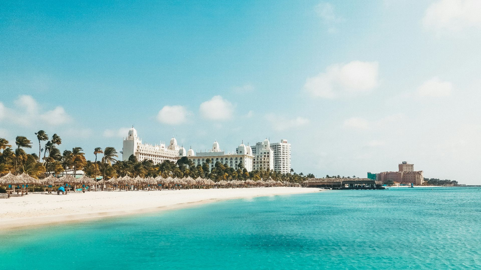 a view of a beach with a hotel in the background