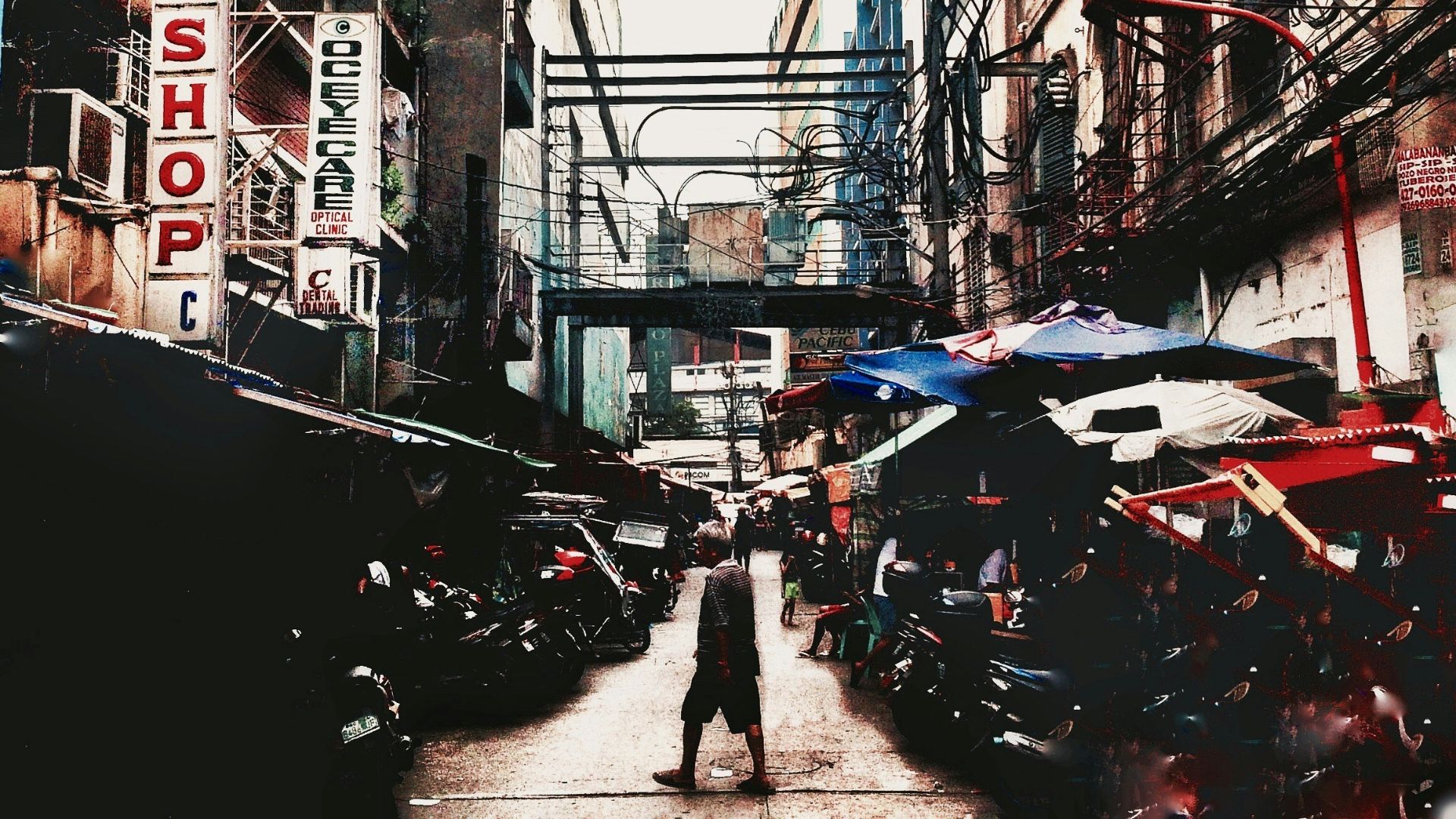 a man walking down a street next to tall buildings