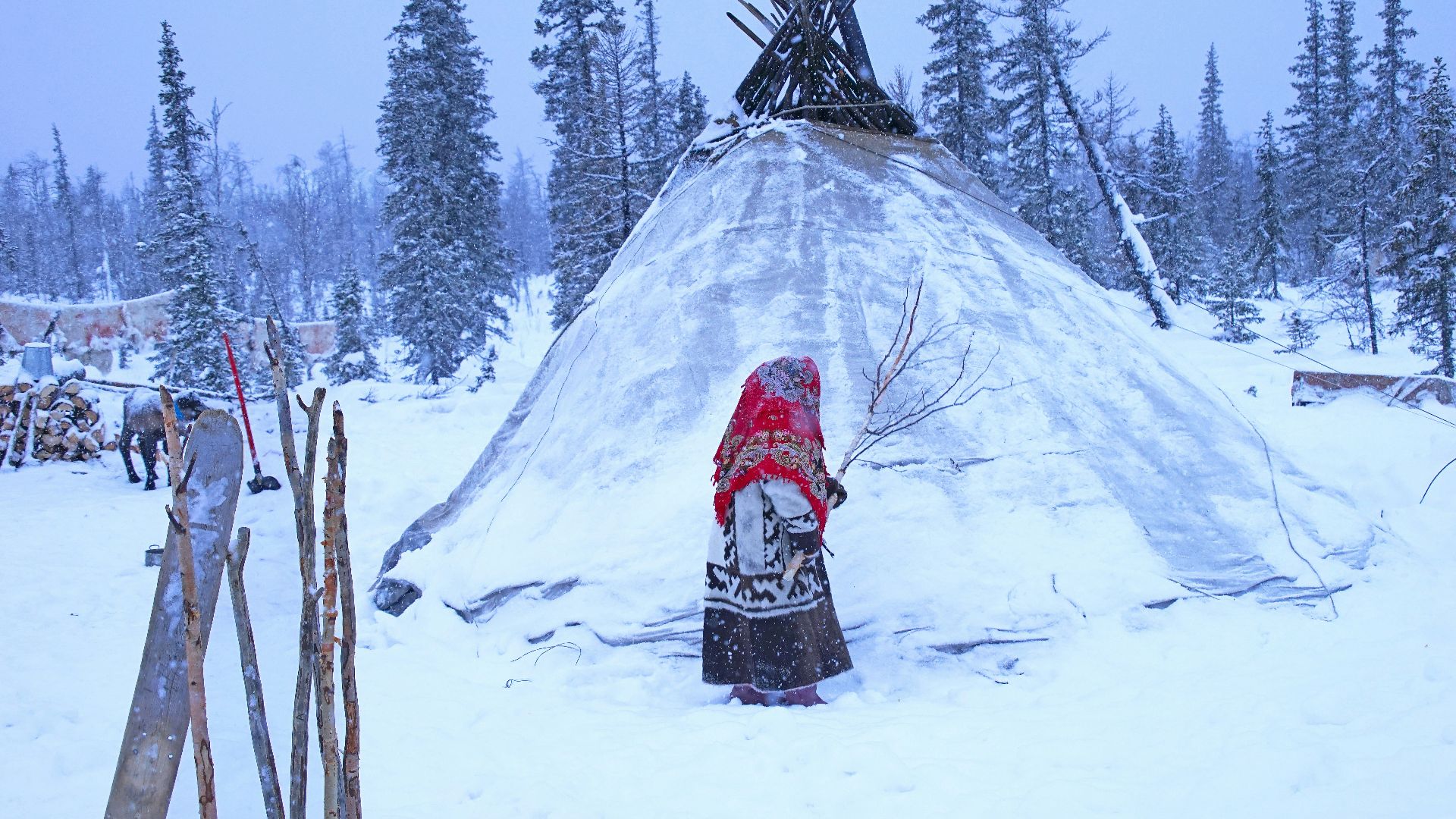 person in red jacket standing on snow covered ground during daytime